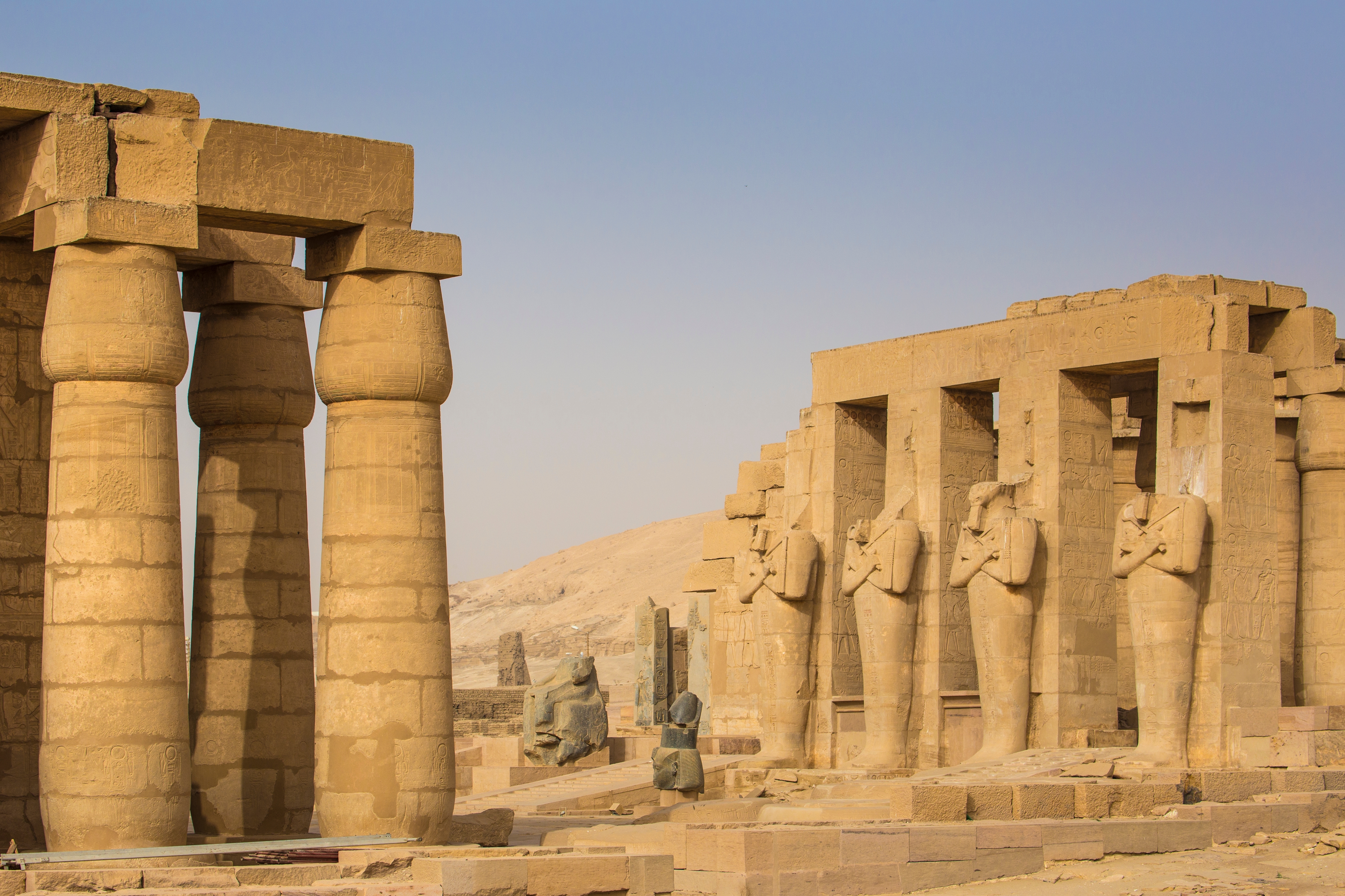 Imponerende egyptiske tempelruiner med massive søjler og skulpturer ved Luxor