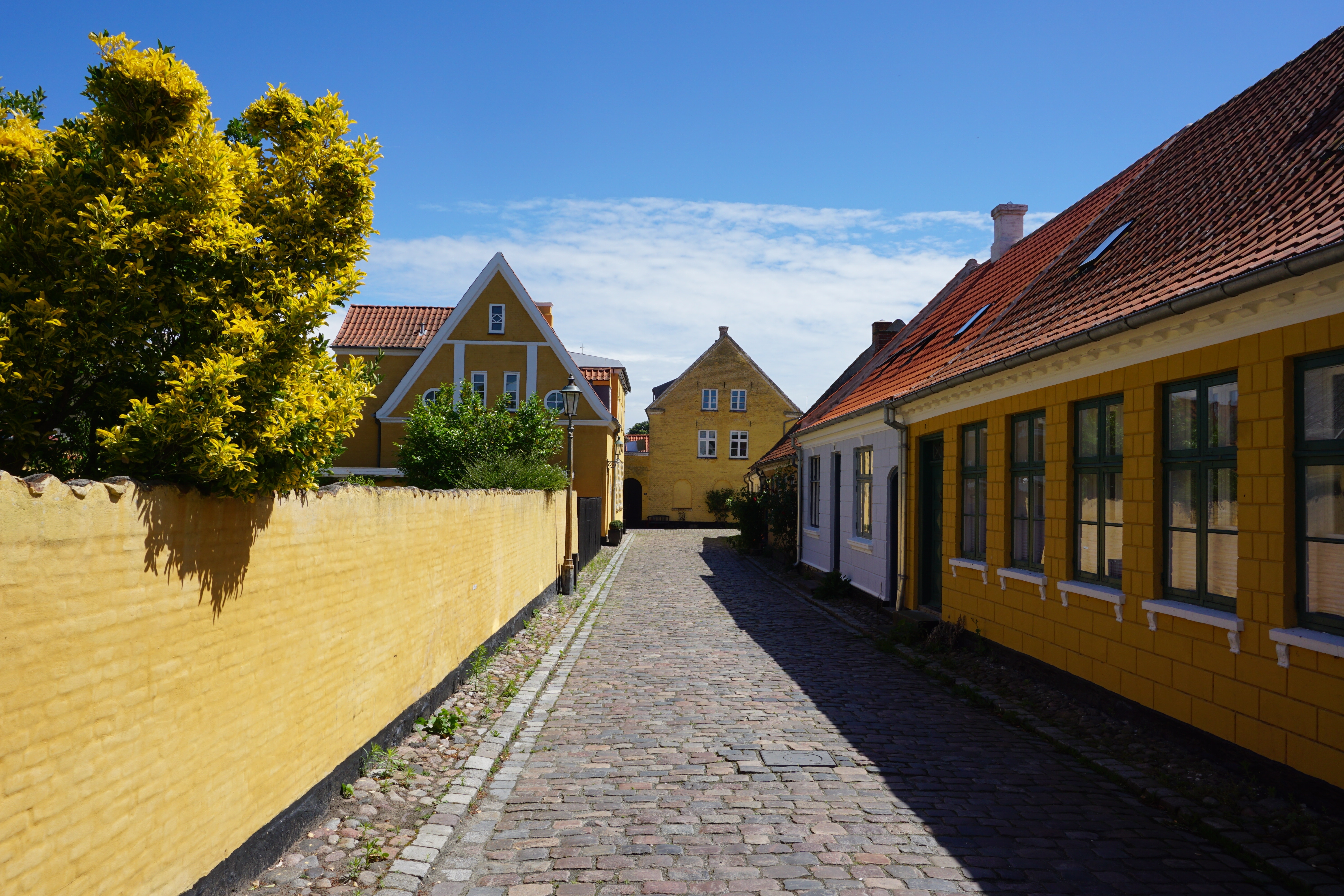 Smuk brolagt gyde med gule huse og rødtage i Ærøskøbing på Ærø, Danmark