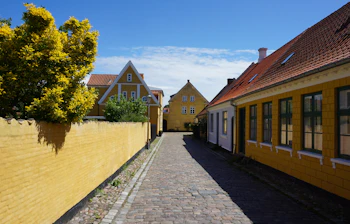 Smuk brolagt gyde med gule huse og rødtage i Ærøskøbing på Ærø, Danmark