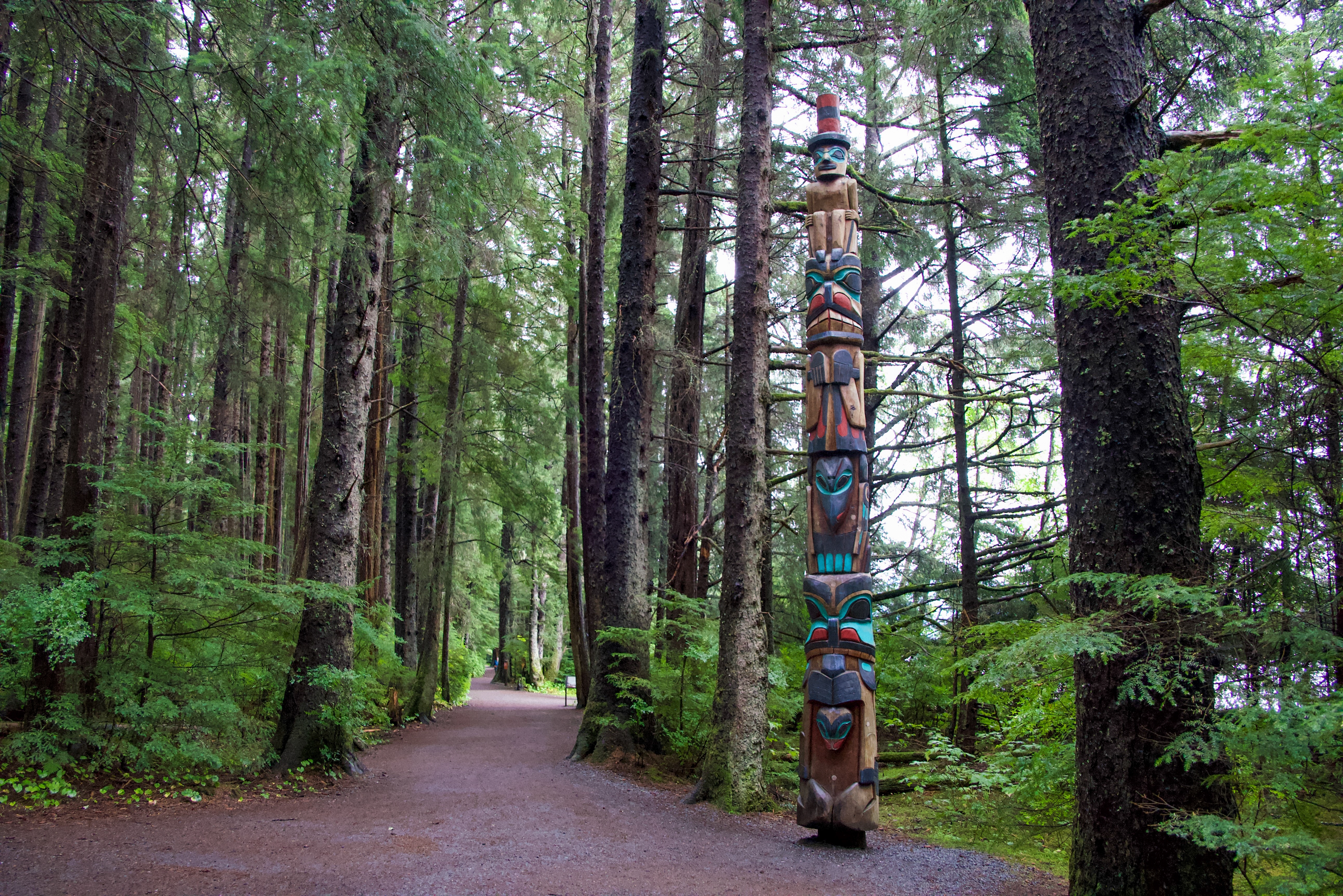Oprindelig indiansk totempæl langs en natursti i den tætte nåleskov i Sitka, Alaska