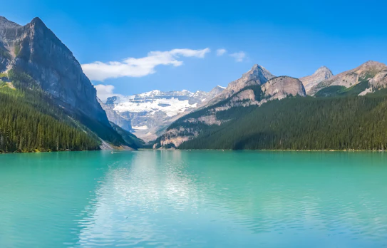 Idyllisk sommerudsigt over den smukke Lake Louise med sin karakteristiske turkise farve, omgivet af majestætiske bjerge og grønne skove i Banff National Park, Alberta, Canada