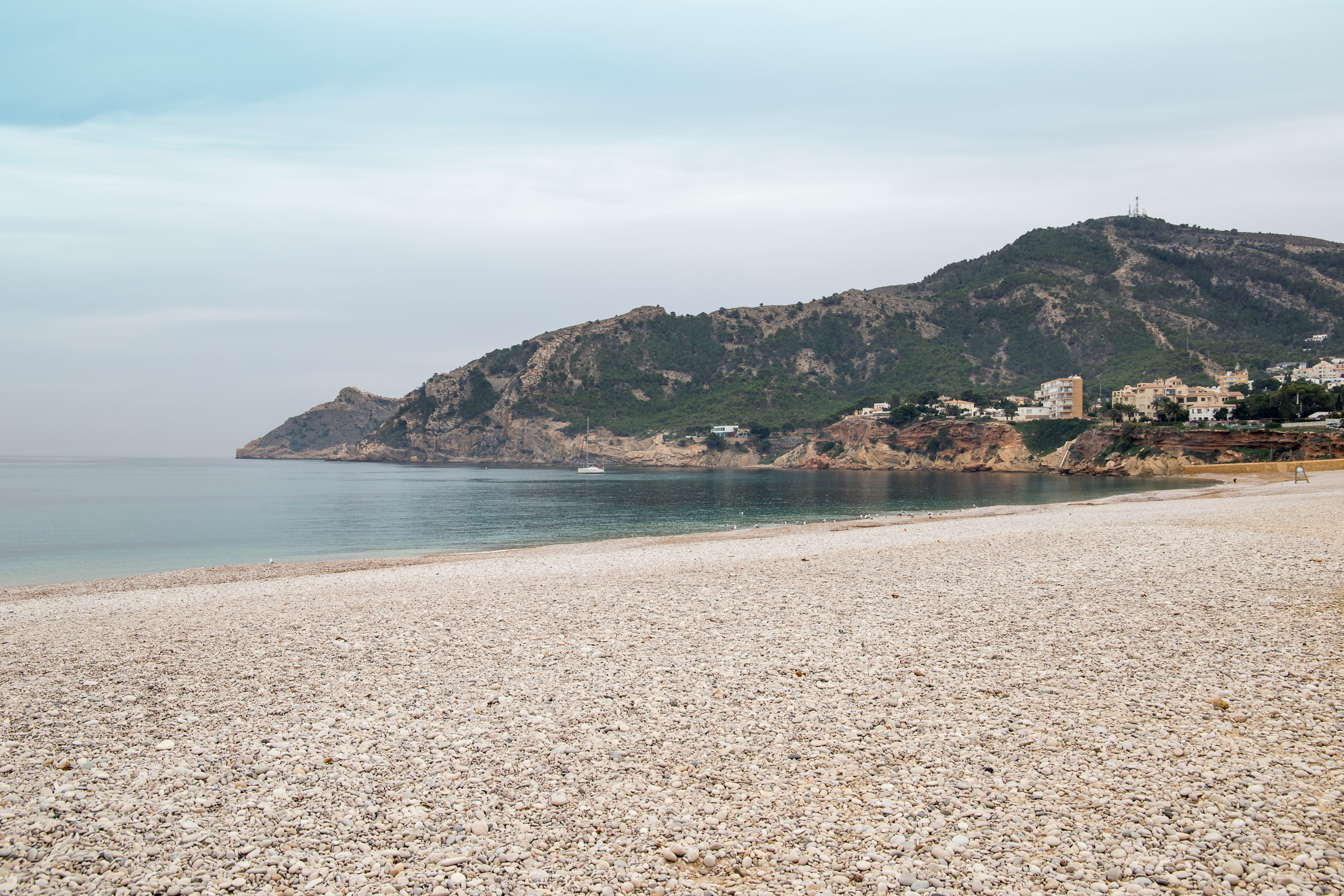 Smuk øde strand ved Albir med det rolige Middelhav og dramatiske bjerge i baggrunden på Costa Blanca nær Alfaz del Pi i Spanien