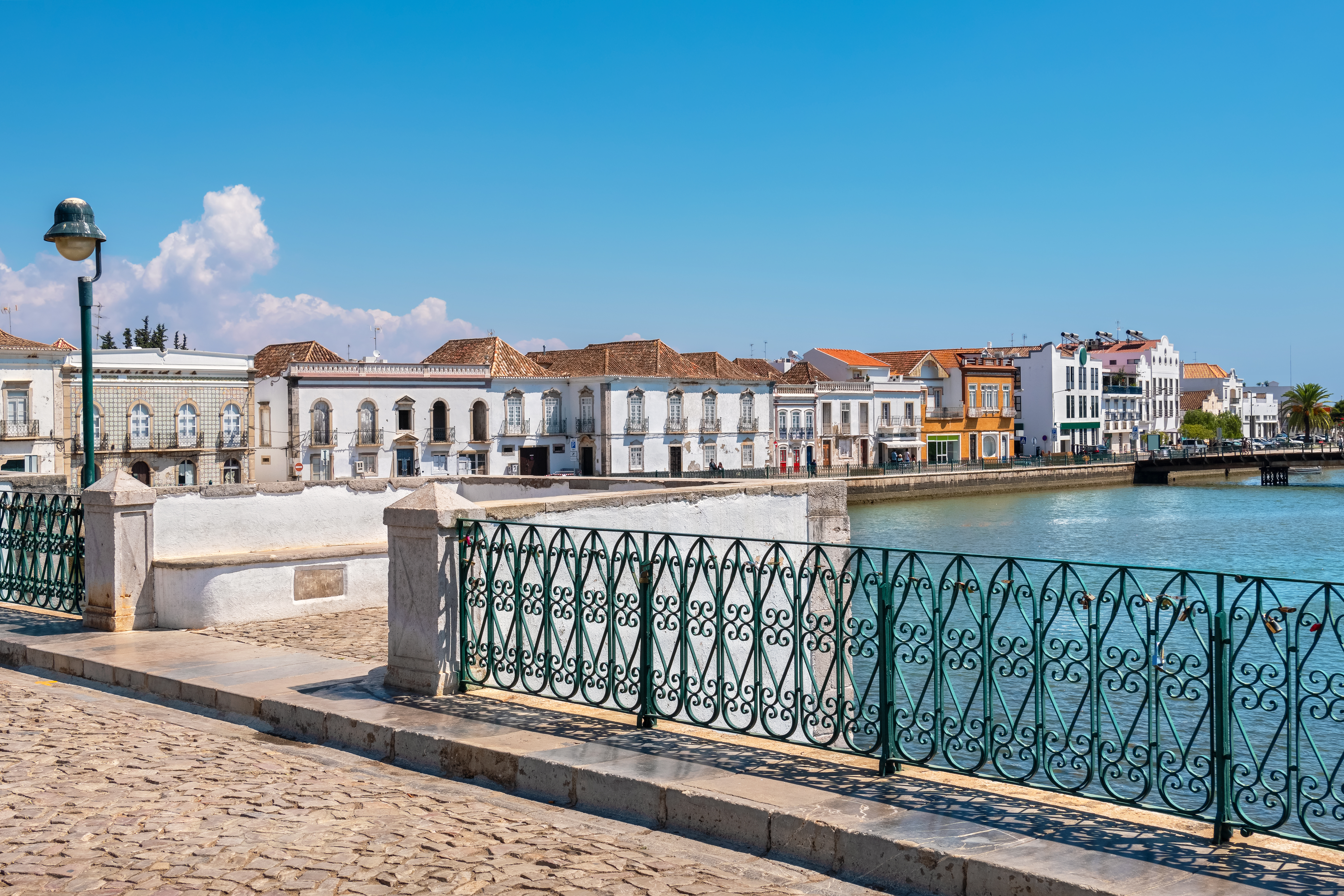 Idyllisk panorama over Tavira med dens traditionelle bygninger og vandfront, set fra den historiske romerske bro over Gilão-floden i Portugals Algarve-region