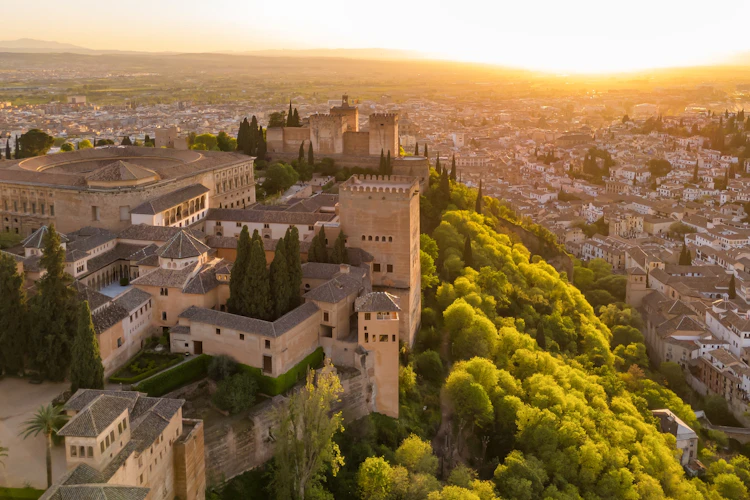Dronefoto af den historiske Alhambra-fæstning og det mauriske palads ved solnedgang i Granada, Andalusien