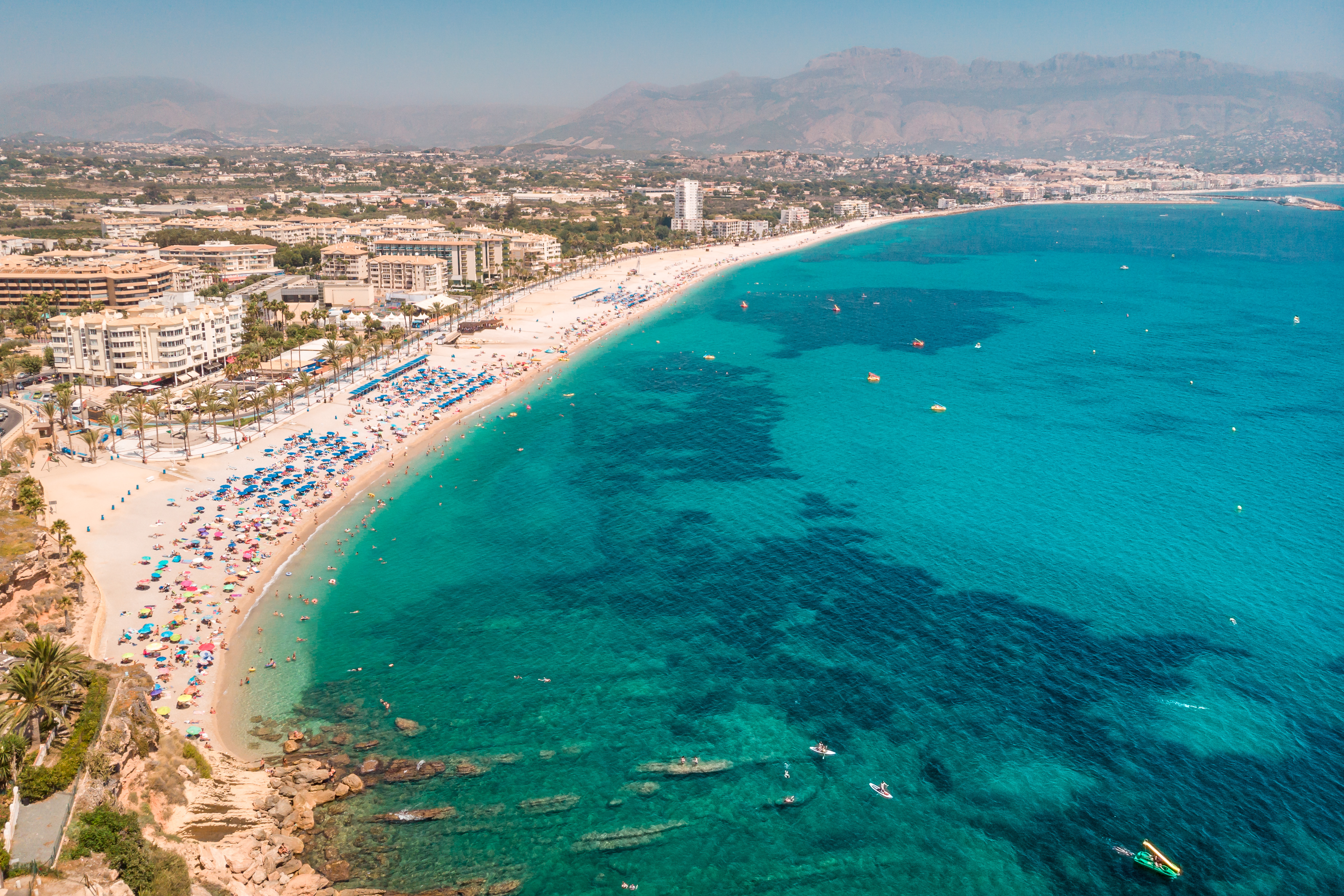 Albir strand ved Alicante Costa Blanca med solbadende turister og turkist havvand