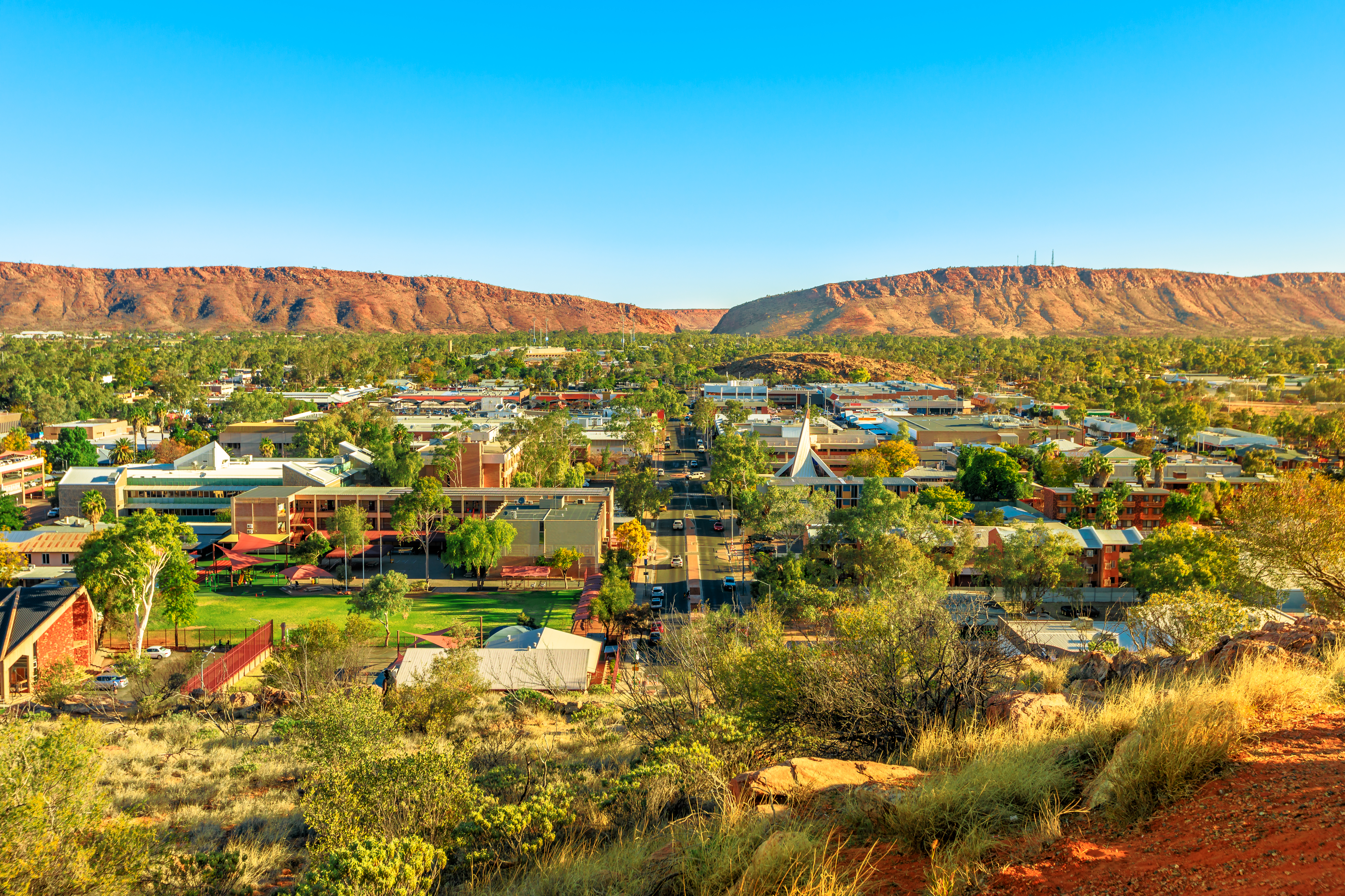 Luftfoto af Alice Springs by omgivet af MacDonnell Ranges bjerge i Australien