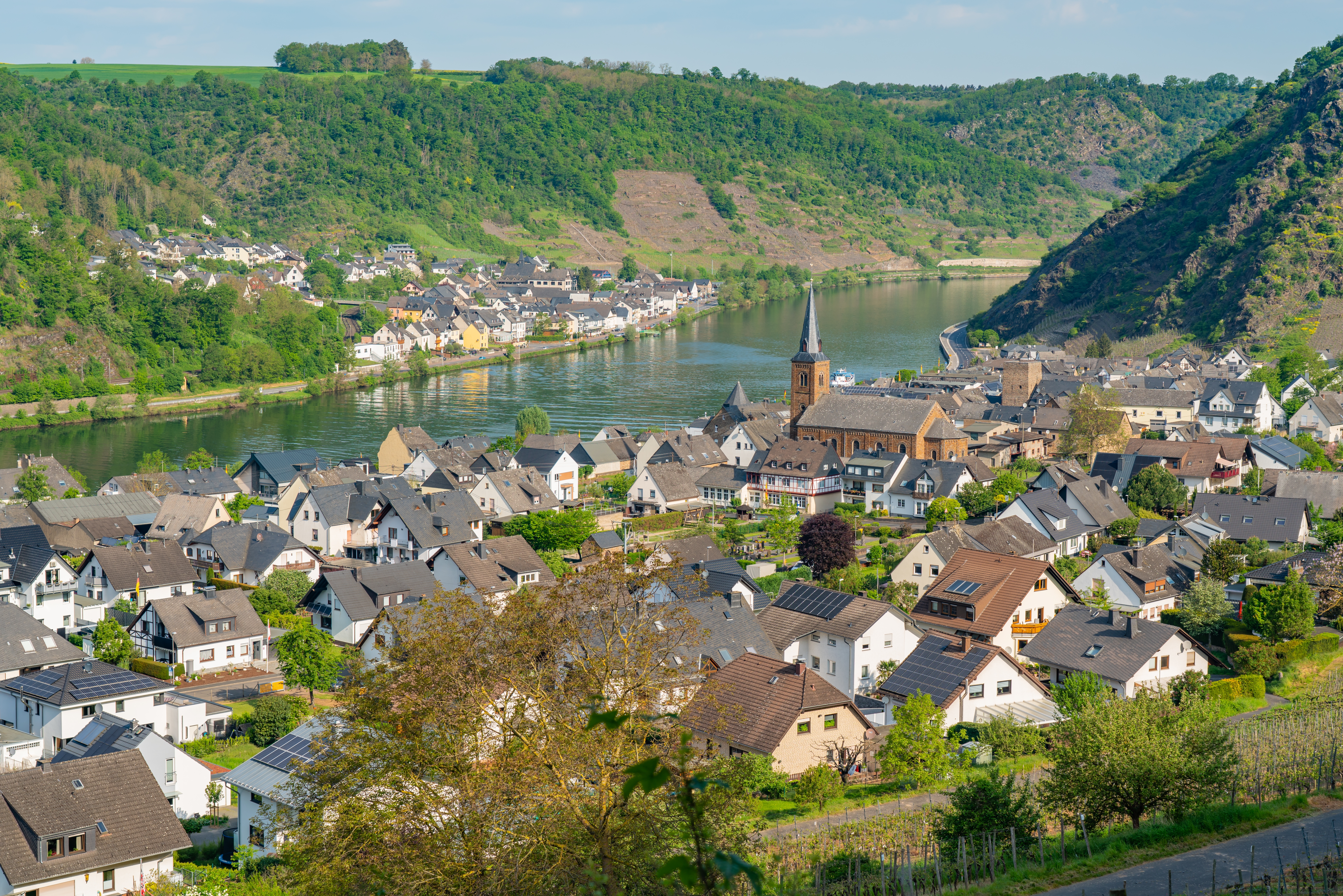 Luftfoto af den stemningsfulde landsby Alken langs Mosellen i Rhinland-Pfalz, Tyskland, omgivet af frodig natur og vingårde