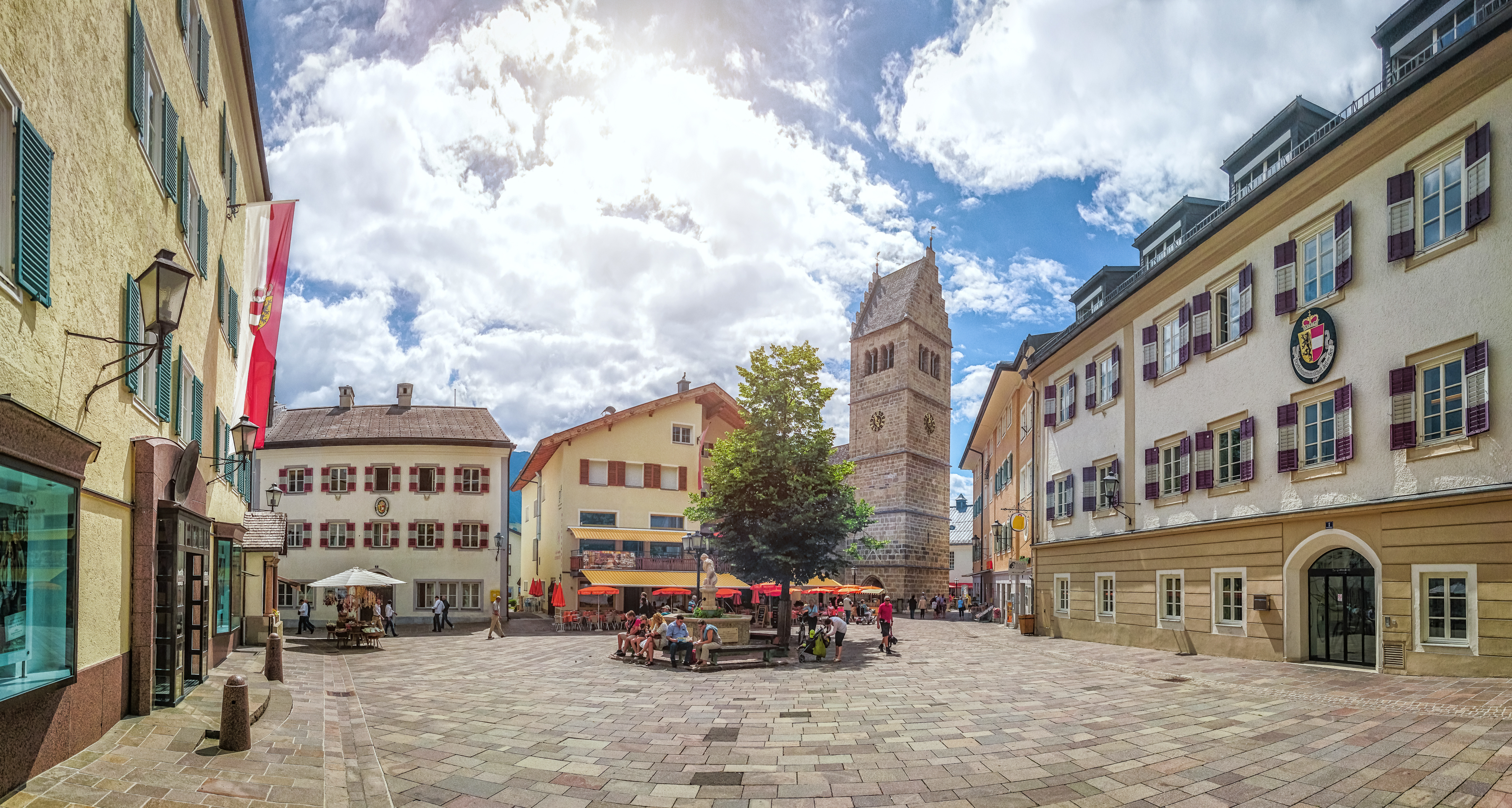 Stemningsfuldt torv i den historiske alpeby Zell am See med traditionelle østrigske bygninger og den romanske St. Hippolyt kirke i hjertet af Salzburgerland