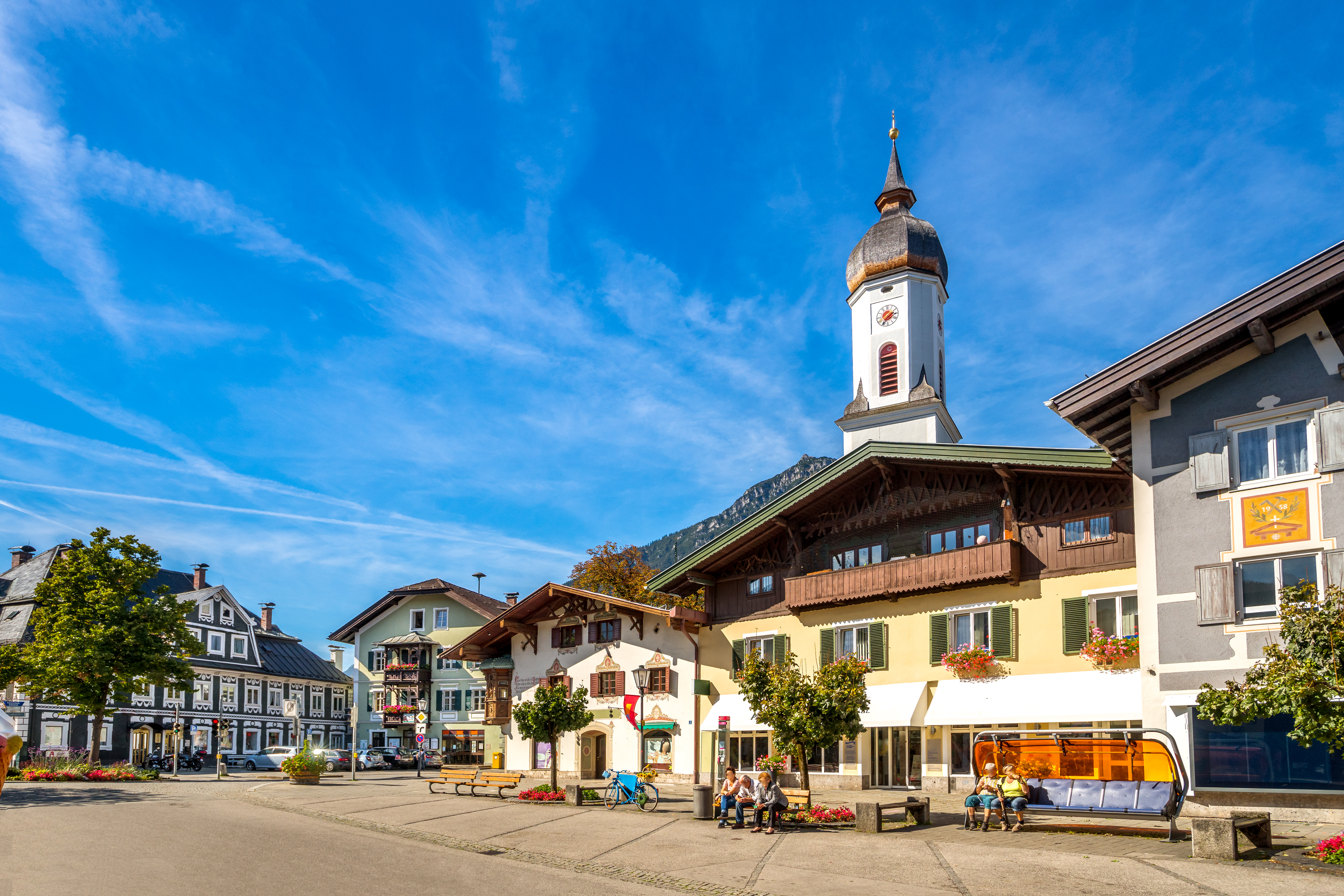 Charmerende alpelandsby i Bayern med traditionelle tyske huse og kirketårn