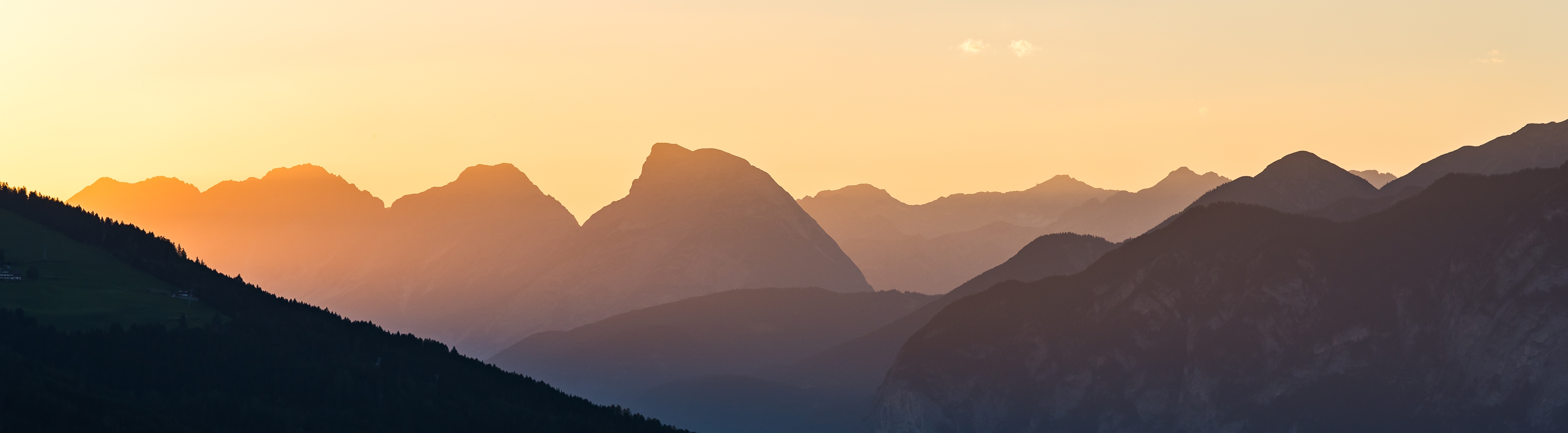 Spektakulær solnedgang bag bjergkæder i de østrigske Alper med orange glød