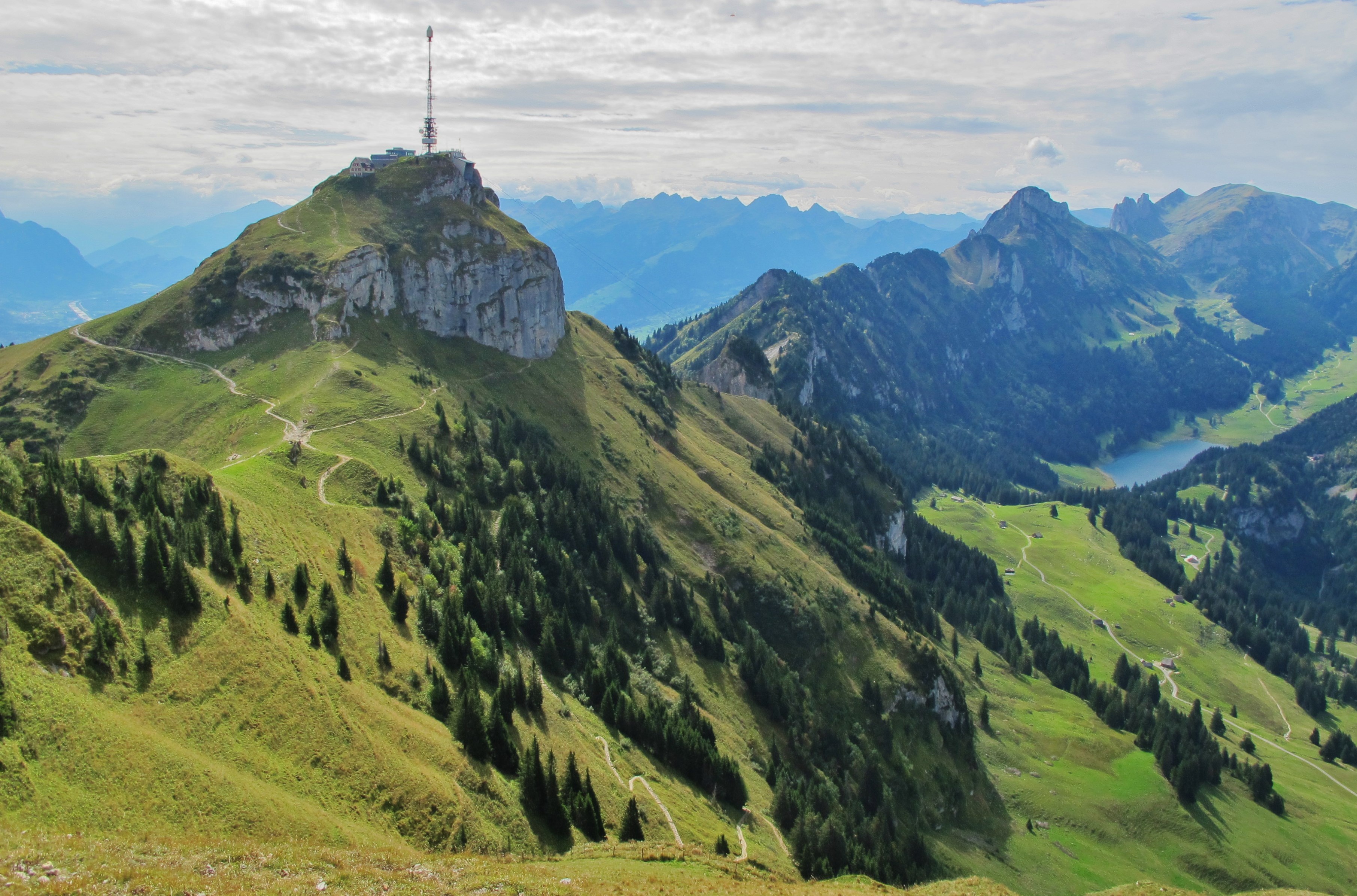 Panoramaudsigt over Hoher Kasten og Alpstein-bjergkæden i Schweiz med grønne alpenge og skov