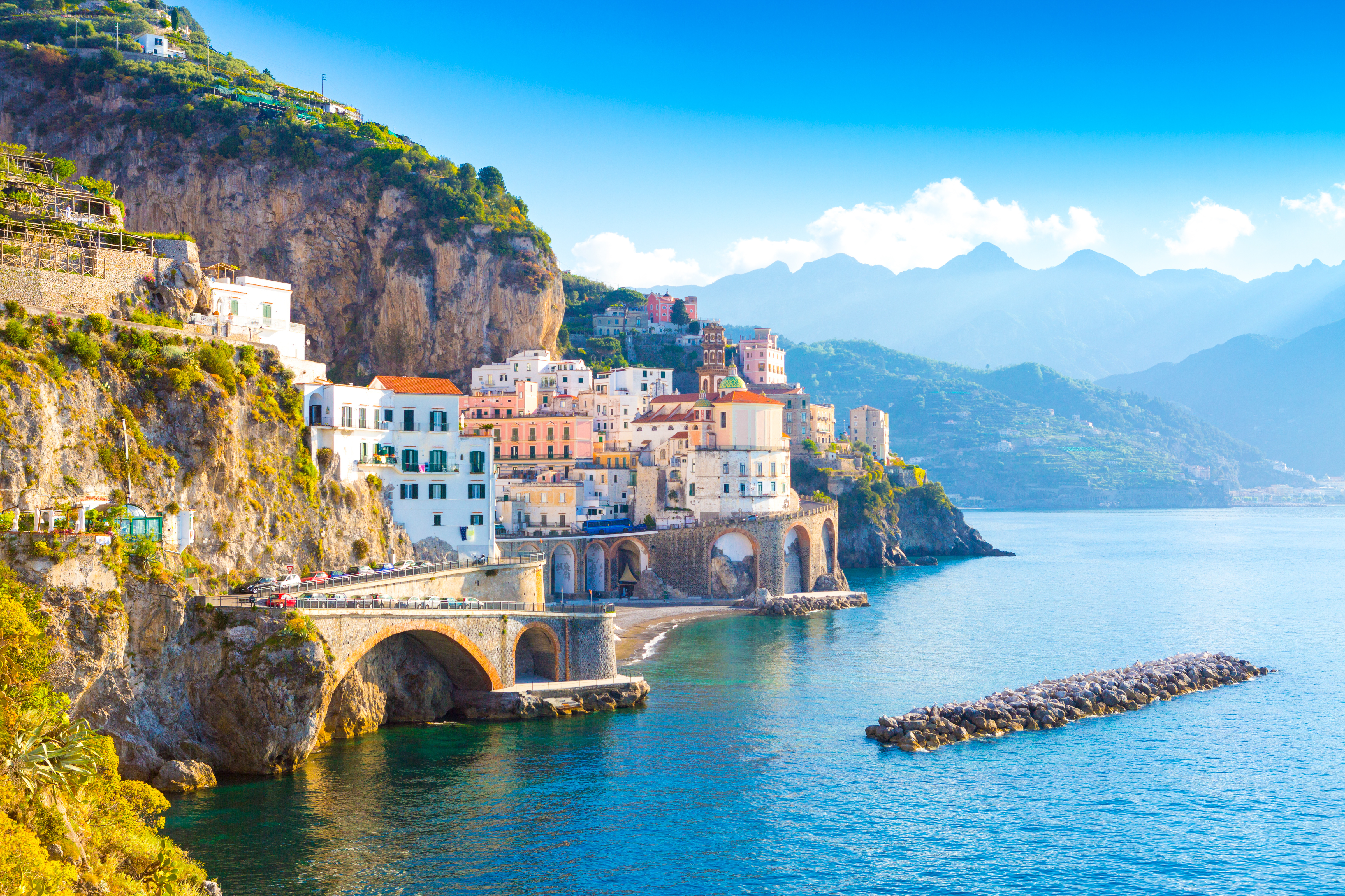 Charmerende morgenudsigt over Amalfi med traditionelle italienske bygninger og kirker omgivet af bjerge ved Middelhavet