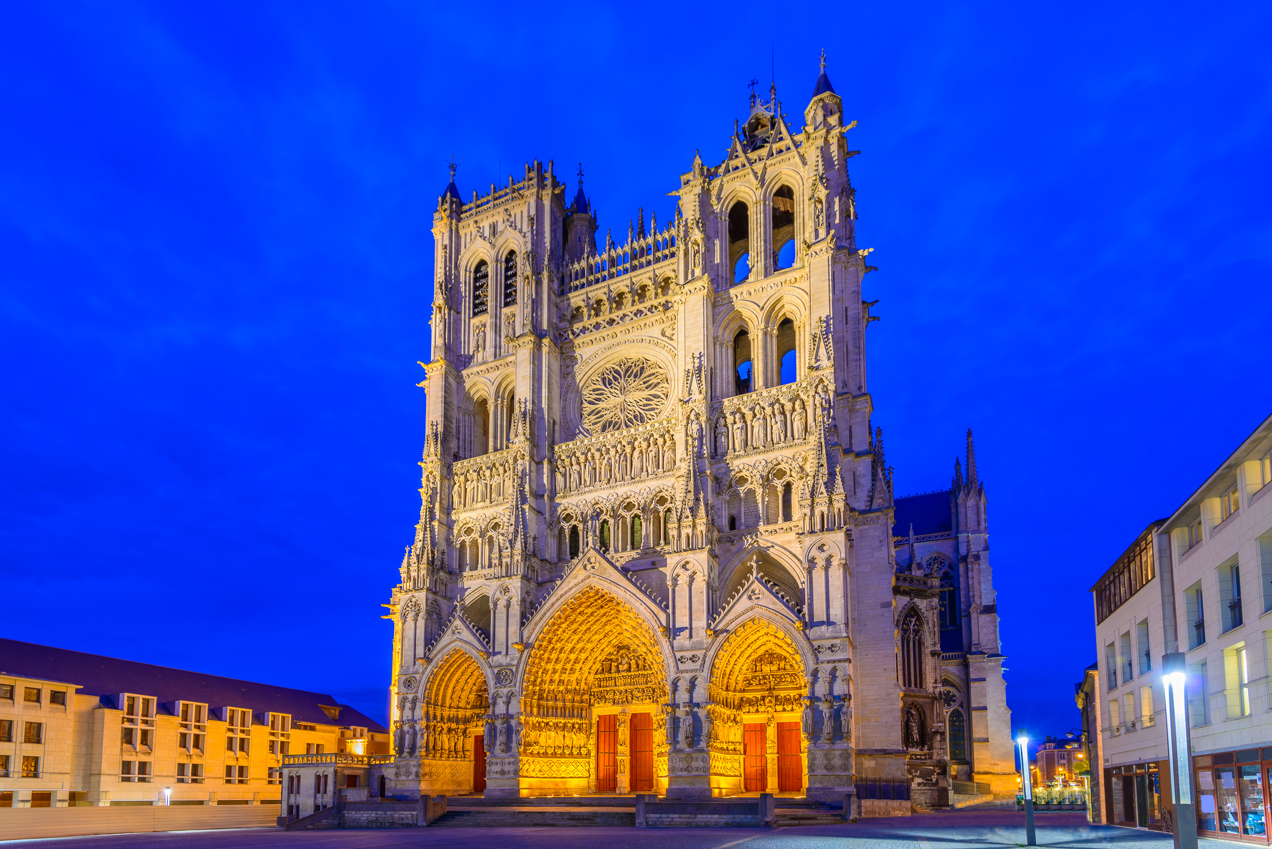 Historisk Notre-Dame de Amiens katedral oplyst om natten, et af Frankrigs mest imponerende gotiske bygningsværker