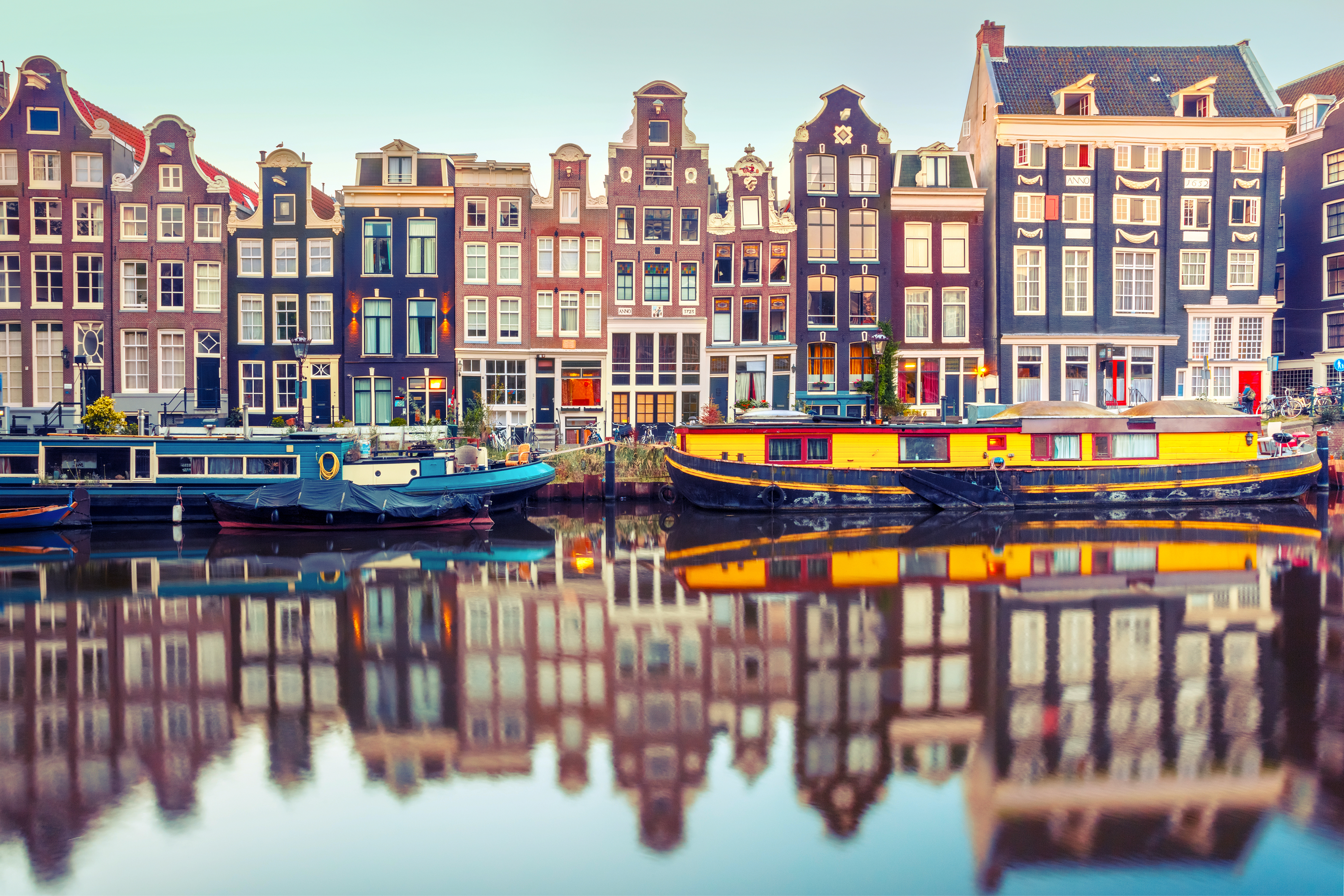 Pittoreske Amsterdam kanalhuse og både med perfekte vandrefleksioner i Holland