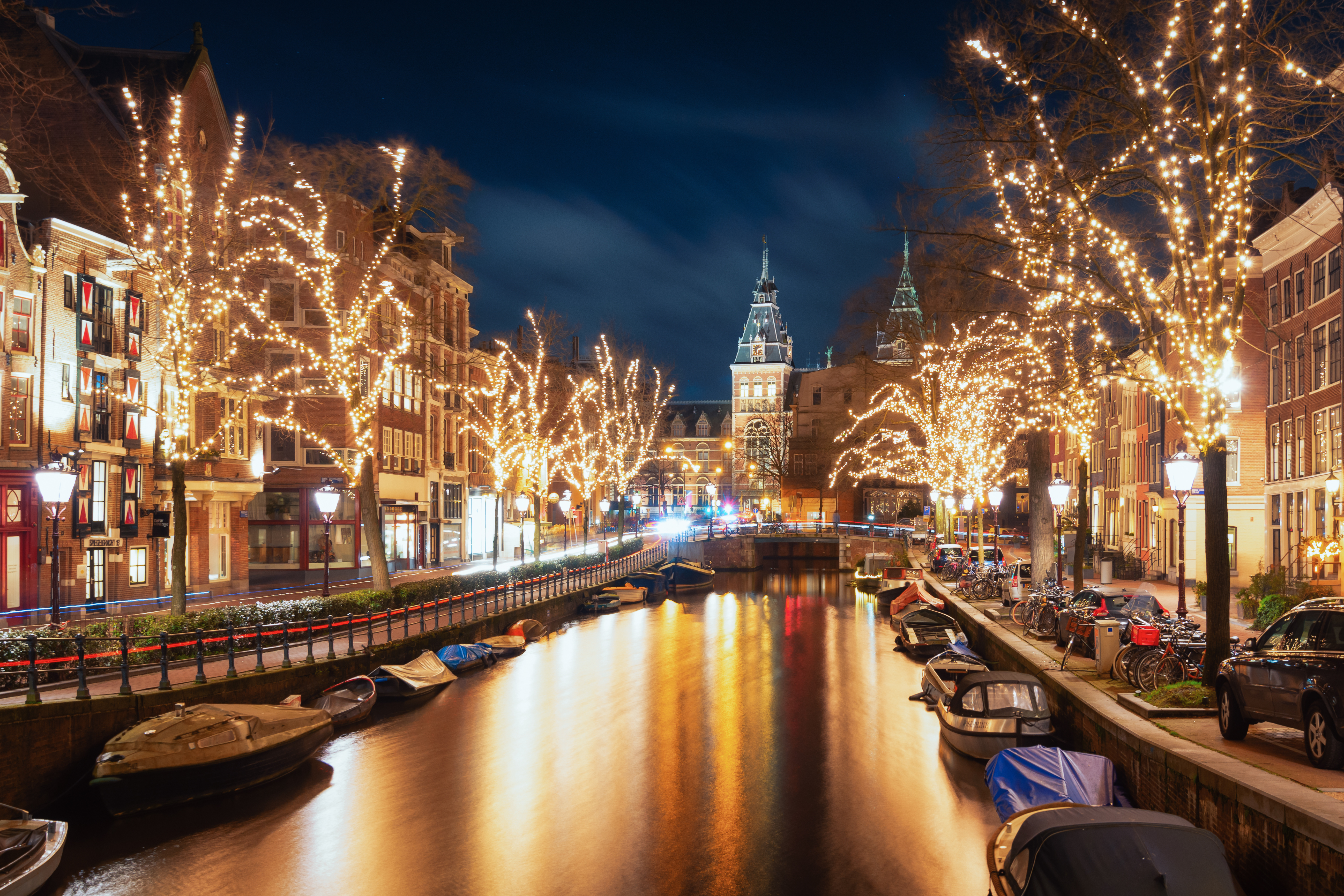 Magisk julestemning i Amsterdam med julelys i træerne langs Spiegelgracht og Rijksmuseum i horisonten