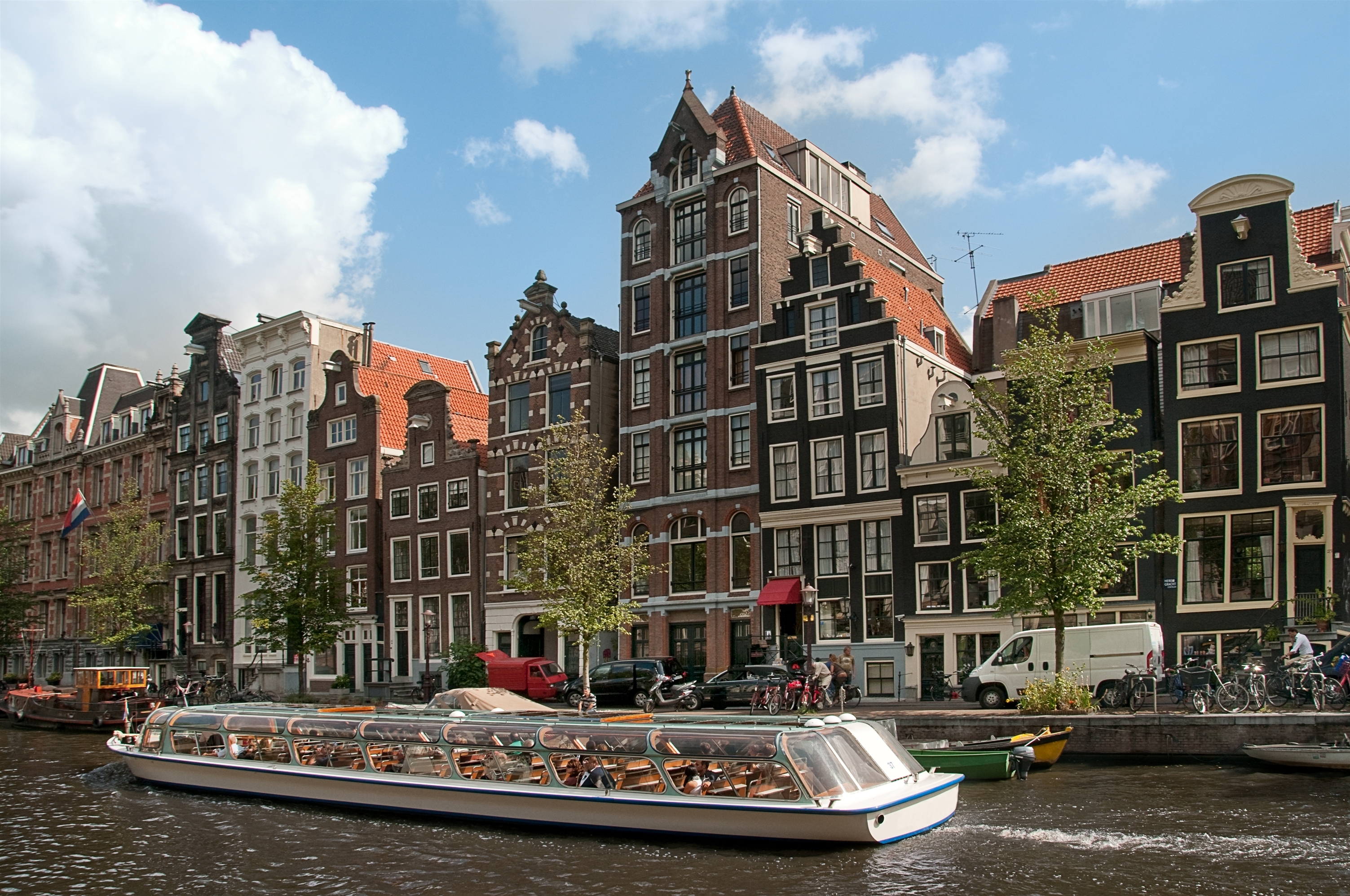 Oplev Amsterdams smukke kanaler og historiske gavlhuse fra en turistbåd på en dejlig sommerdag