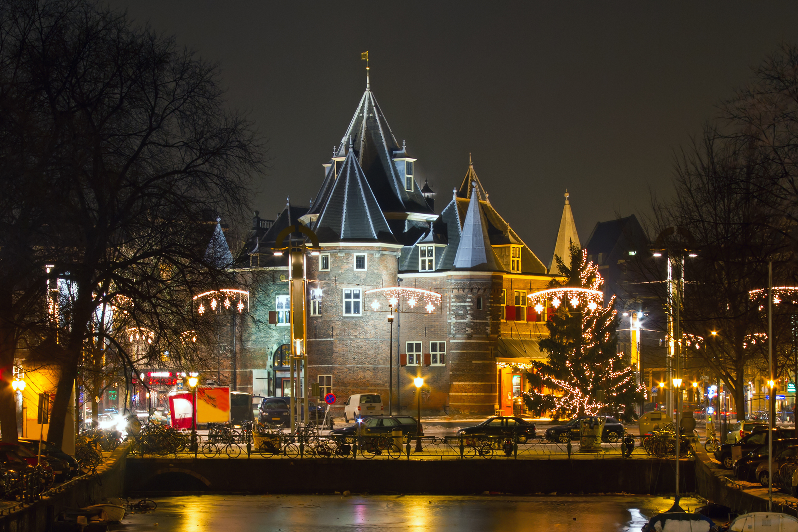 Det middelalderlige Waag-tårn på Nieuwmarkt plads i Amsterdam pyntet med jullys og festlig belysning i den kolde vinternat