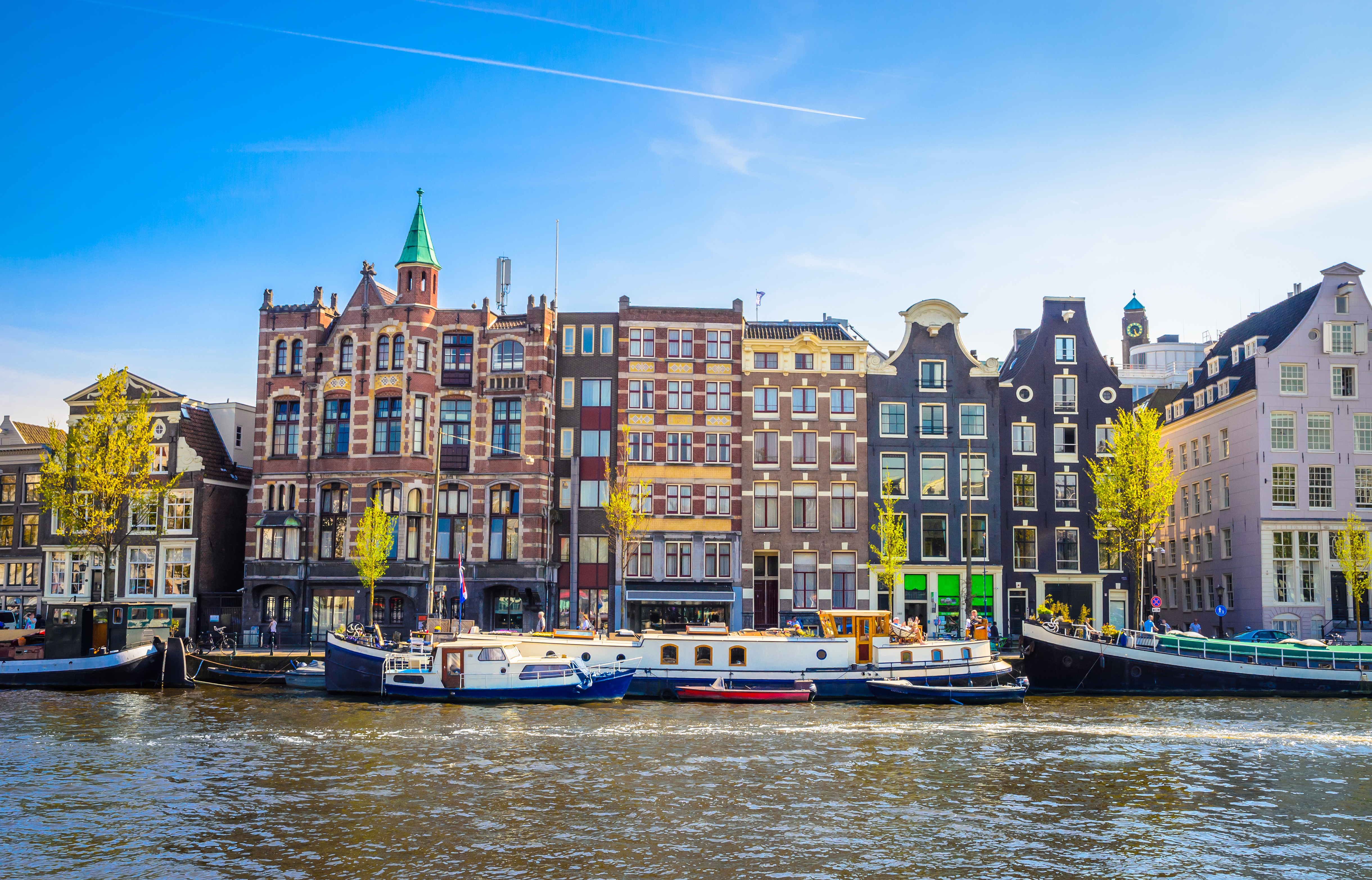 Historiske hollandske kanalhuse og baade i Amsterdam ved de kendte kanaler i Nederlandene