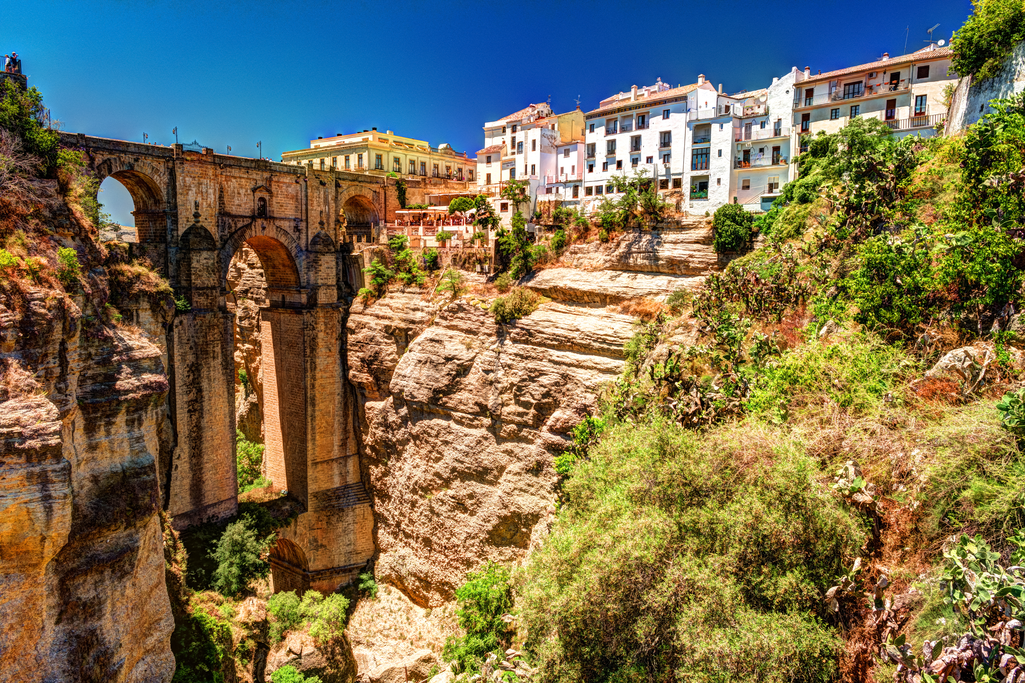 Andalusiens smukke Ronda med historisk stenbro og traditionelle spanske huse på klippe