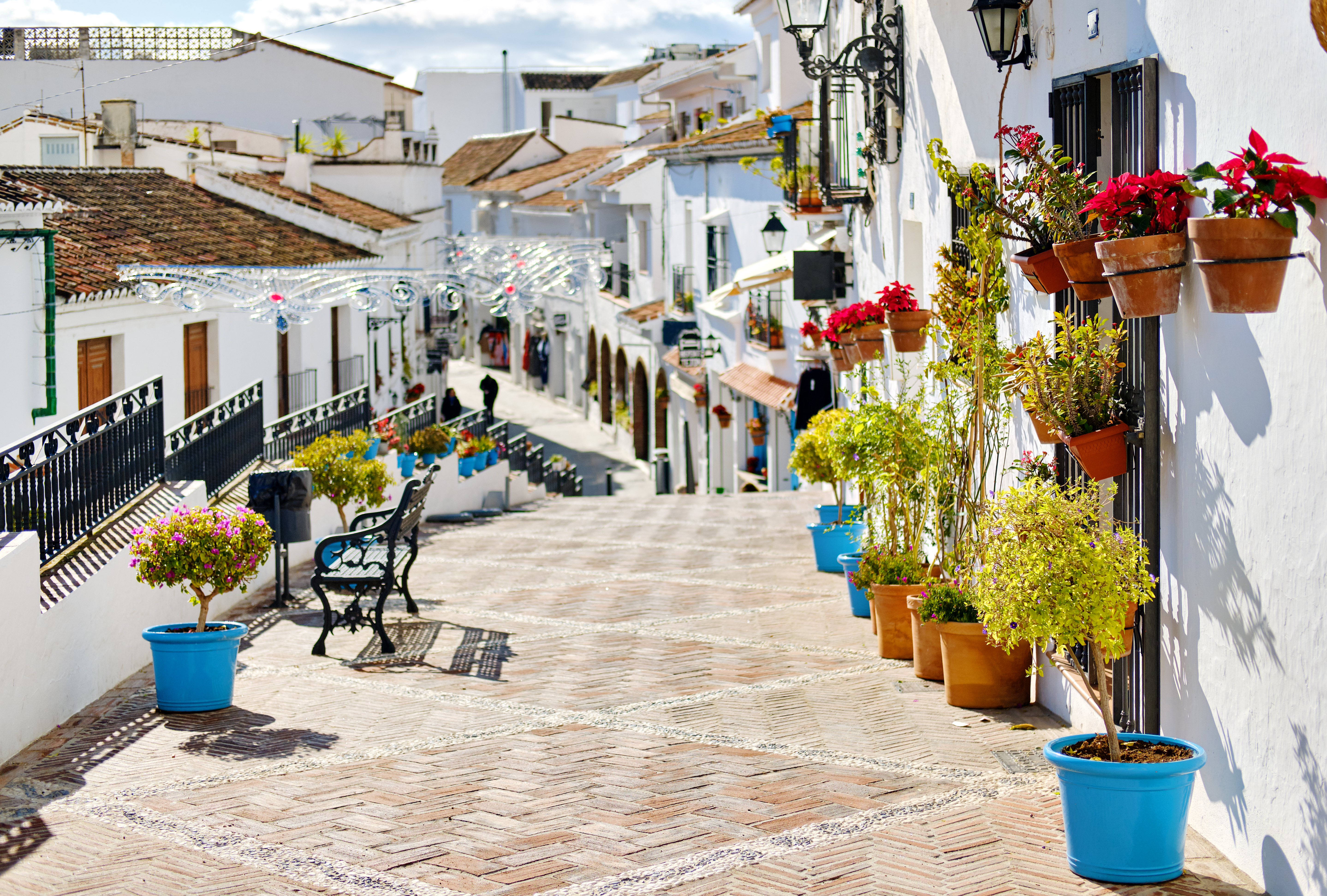 Smuk andalusisk arkitektur med hvide facader og blomsterdekorationer i spansk bjerglandsby