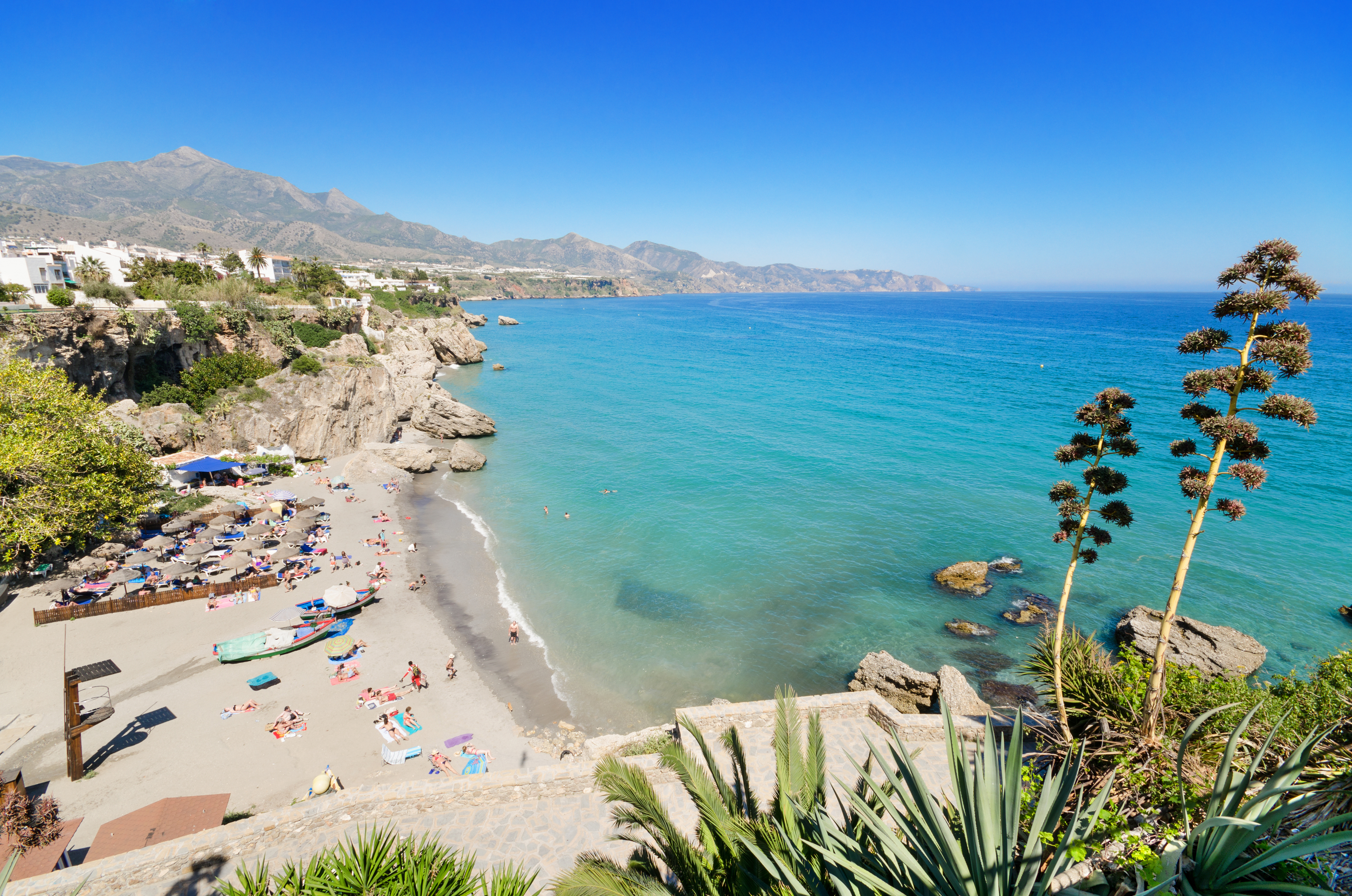 Idyllisk badestrand i Nerja Andalusien med solsenge og turkist vand