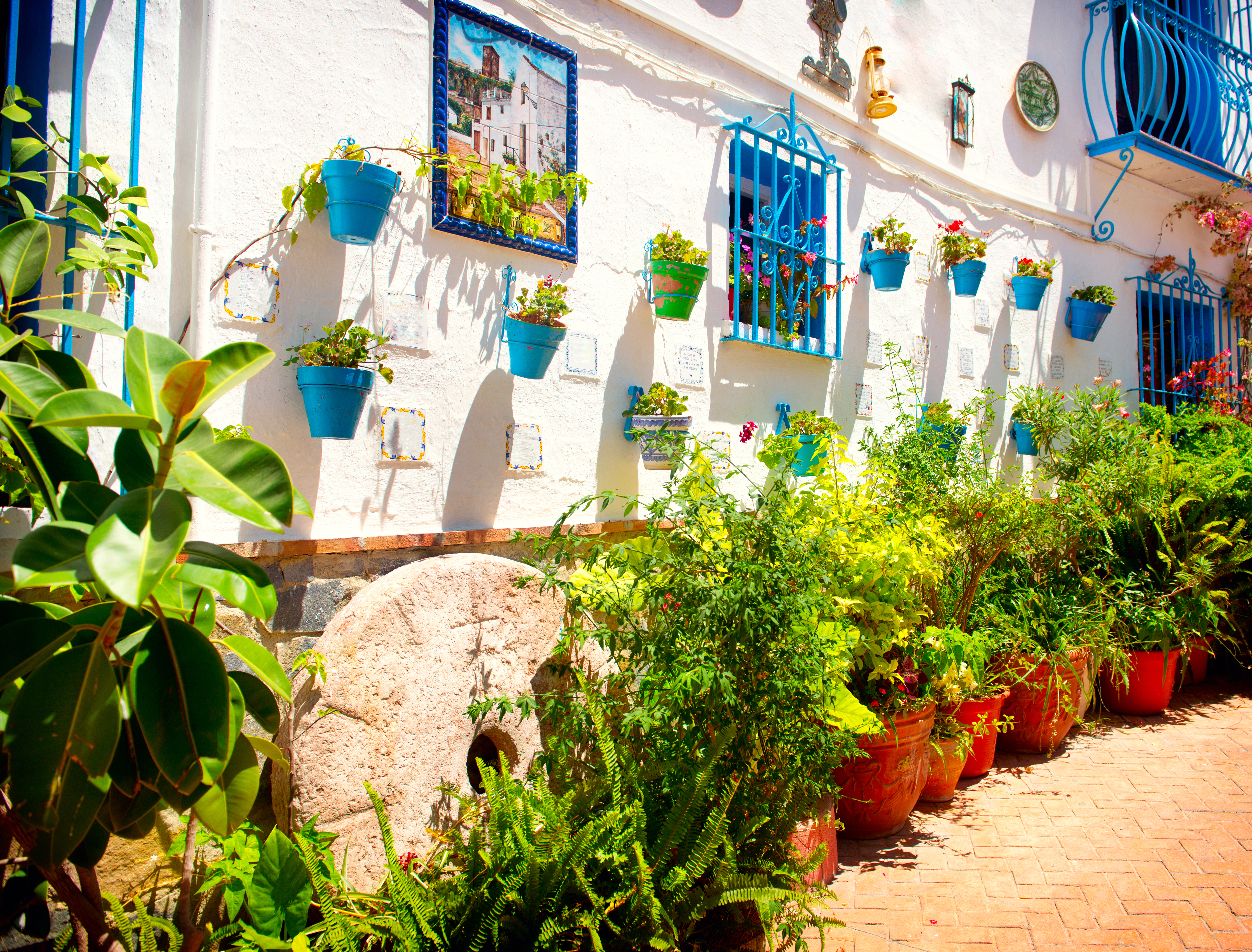 Autentisk andalusisk gård med traditionel hvid arkitektur og blå vinduer og krukker