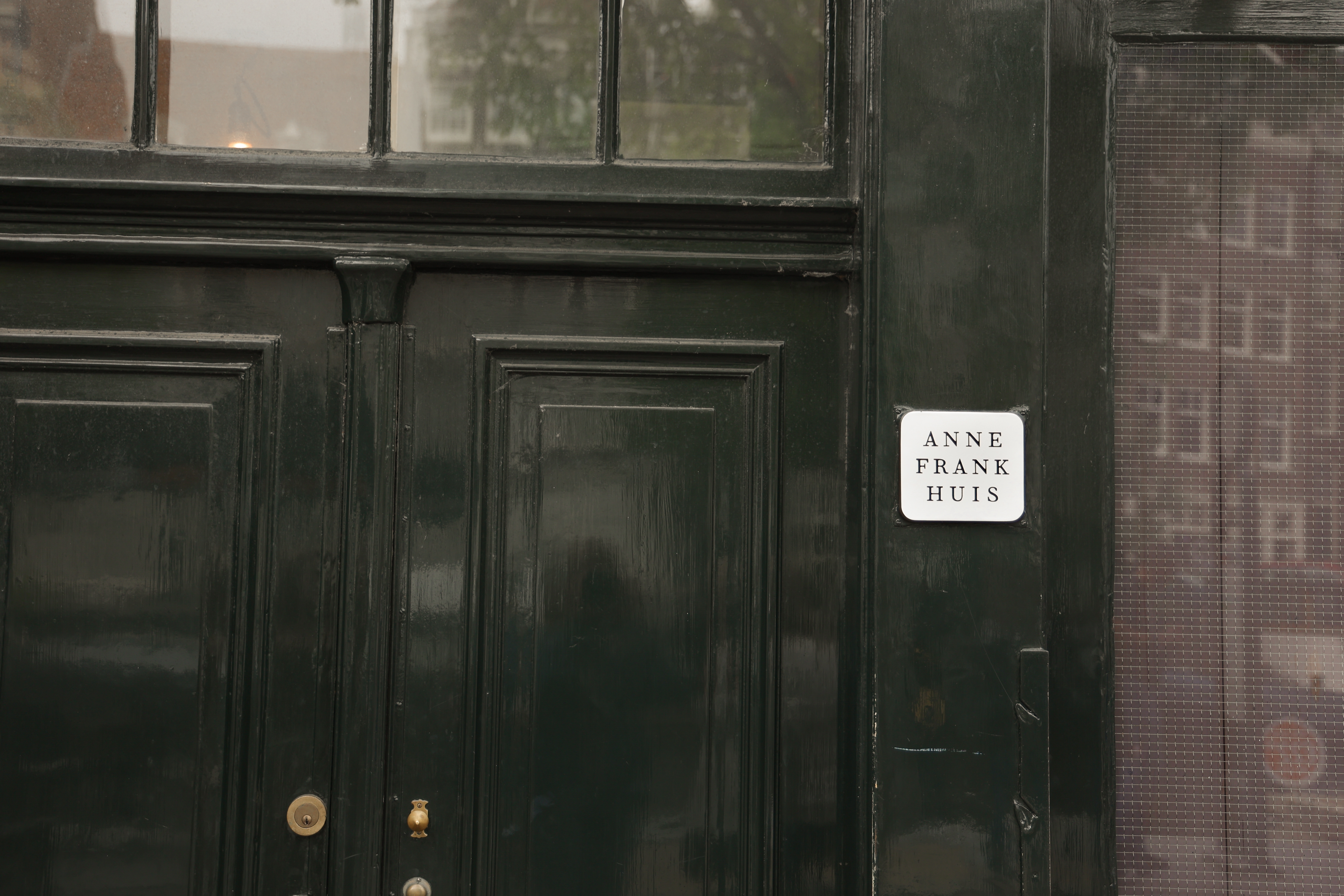 Entrédøren til Anne Frank Huis i Amsterdam med skilt - besøg dette berømte historiske museum i Holland og oplev historien om 2. verdenskrig
