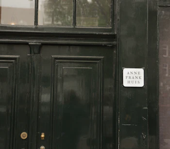 Entrédøren til Anne Frank Huis i Amsterdam med skilt - besøg dette berømte historiske museum i Holland og oplev historien om 2. verdenskrig