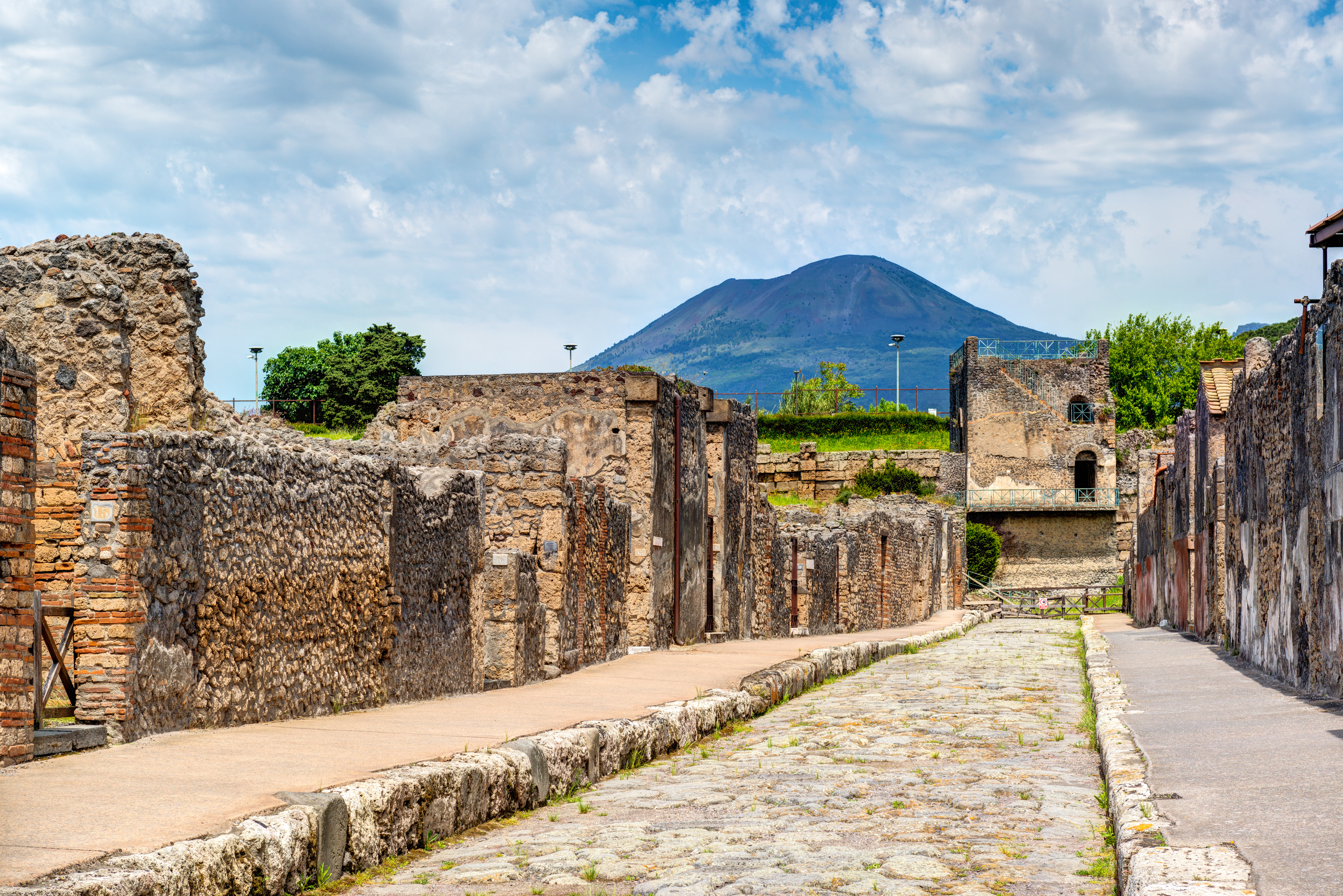 Brosten gade gennem antikke Pompeii ruiner med Vesuv i horisonten, Syditalien
