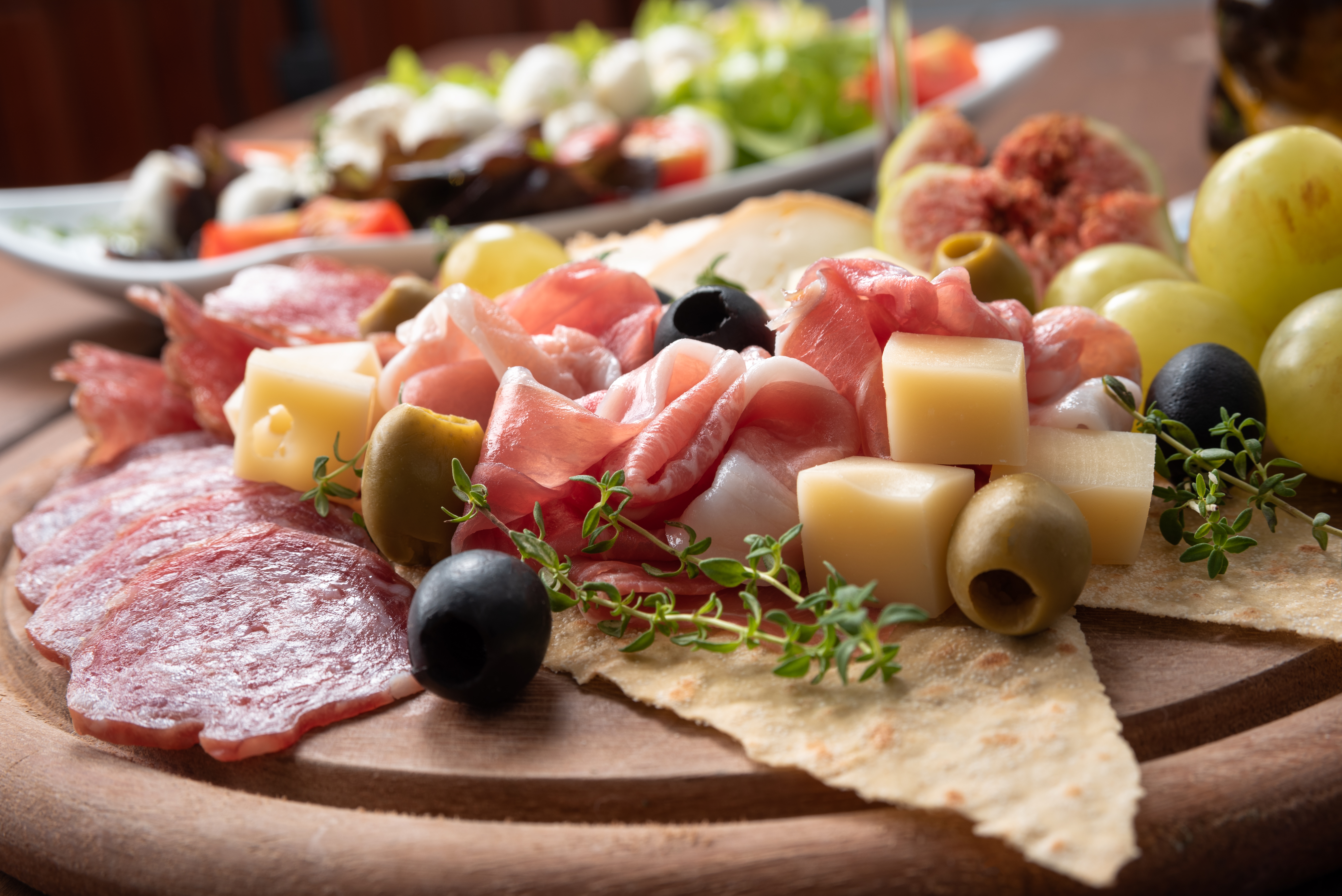 Antipasti tallerken fra Italien med prosciutto, ost, oliven og urter