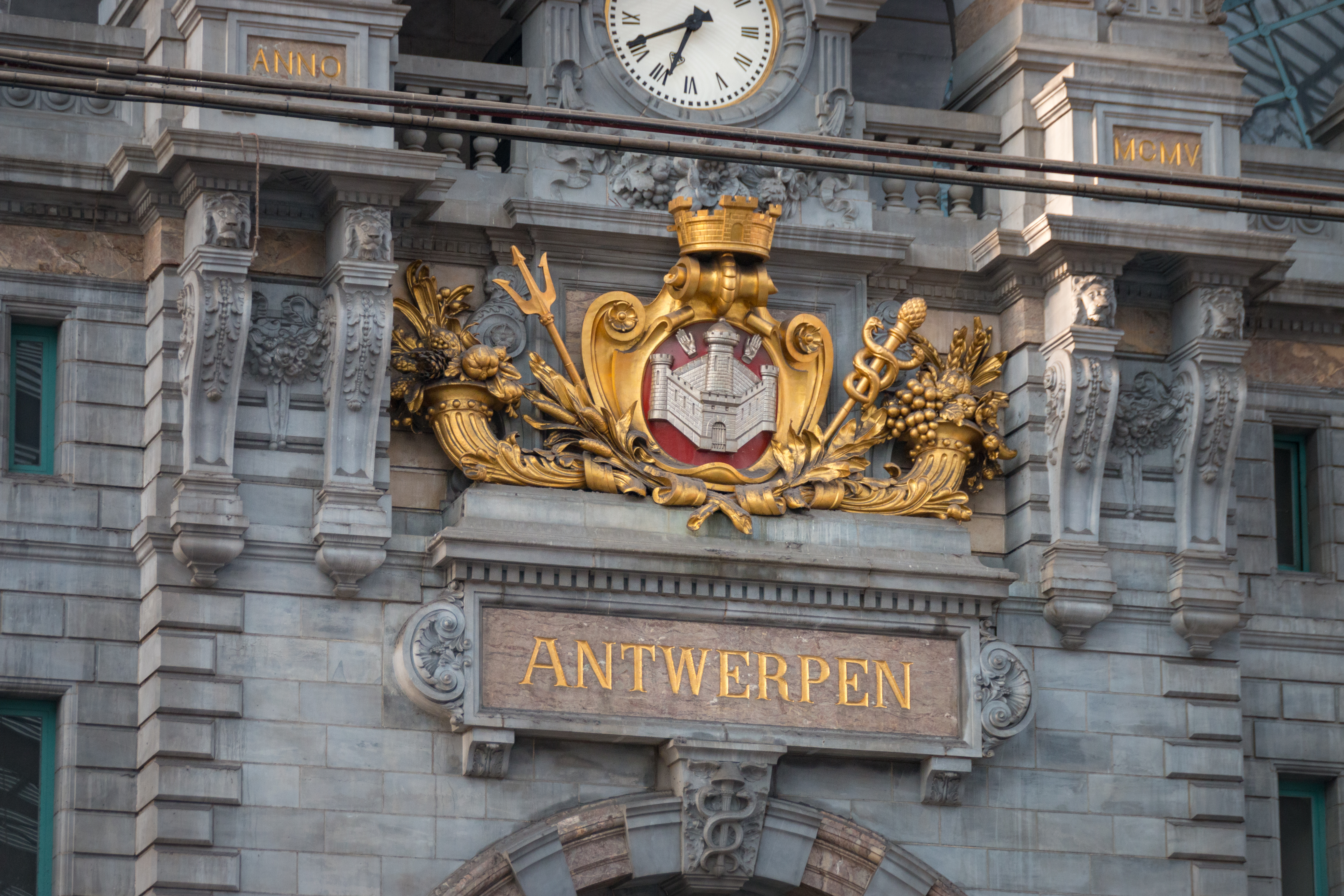 Antwerpen Centralstations monumentale facade med gyldent våbenskjold og klassiske søjler