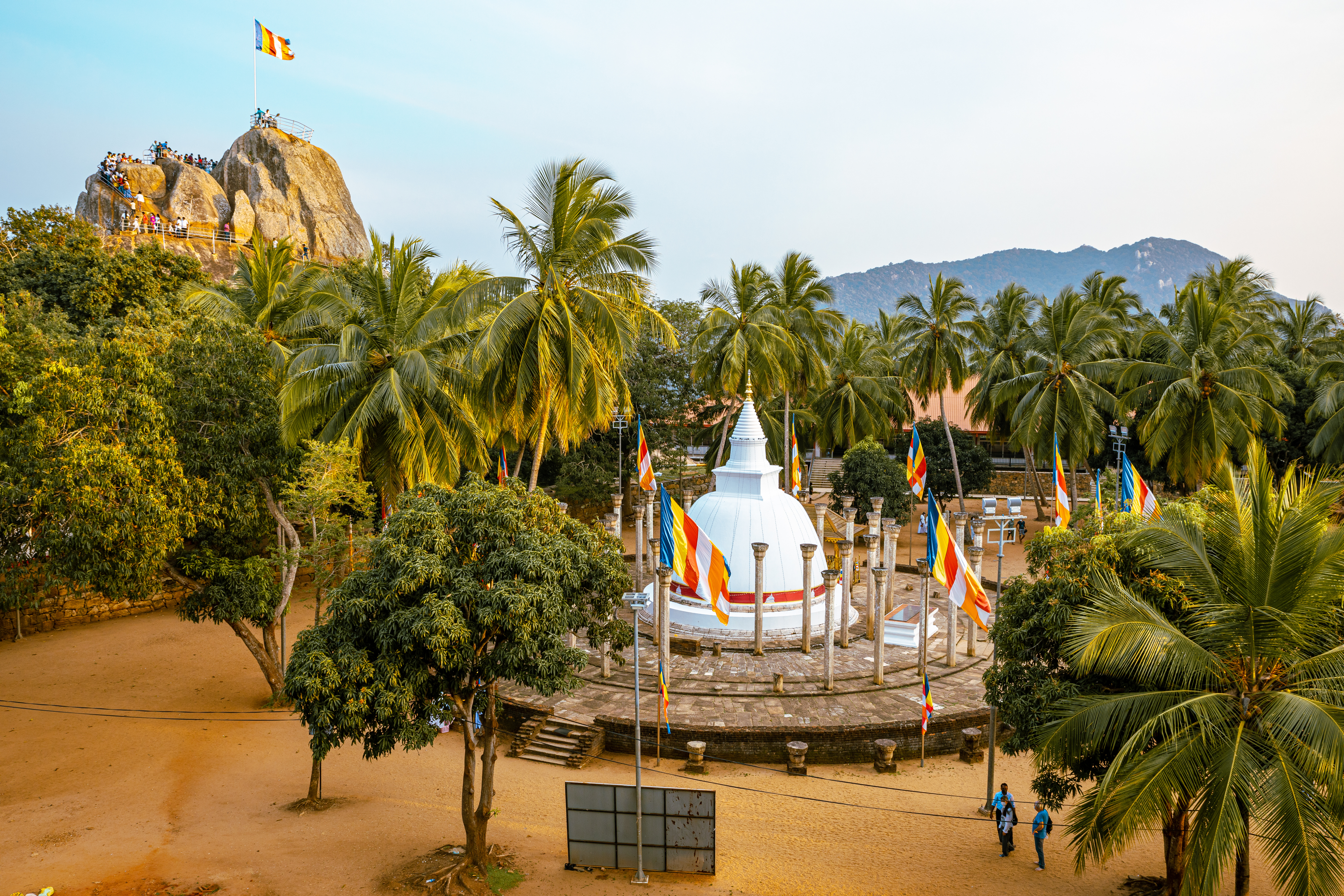 Fredfyldt buddhistisk tempelplads med hvid stupa og bønneflag i Mihintale nær Anuradhapura på Sri Lanka