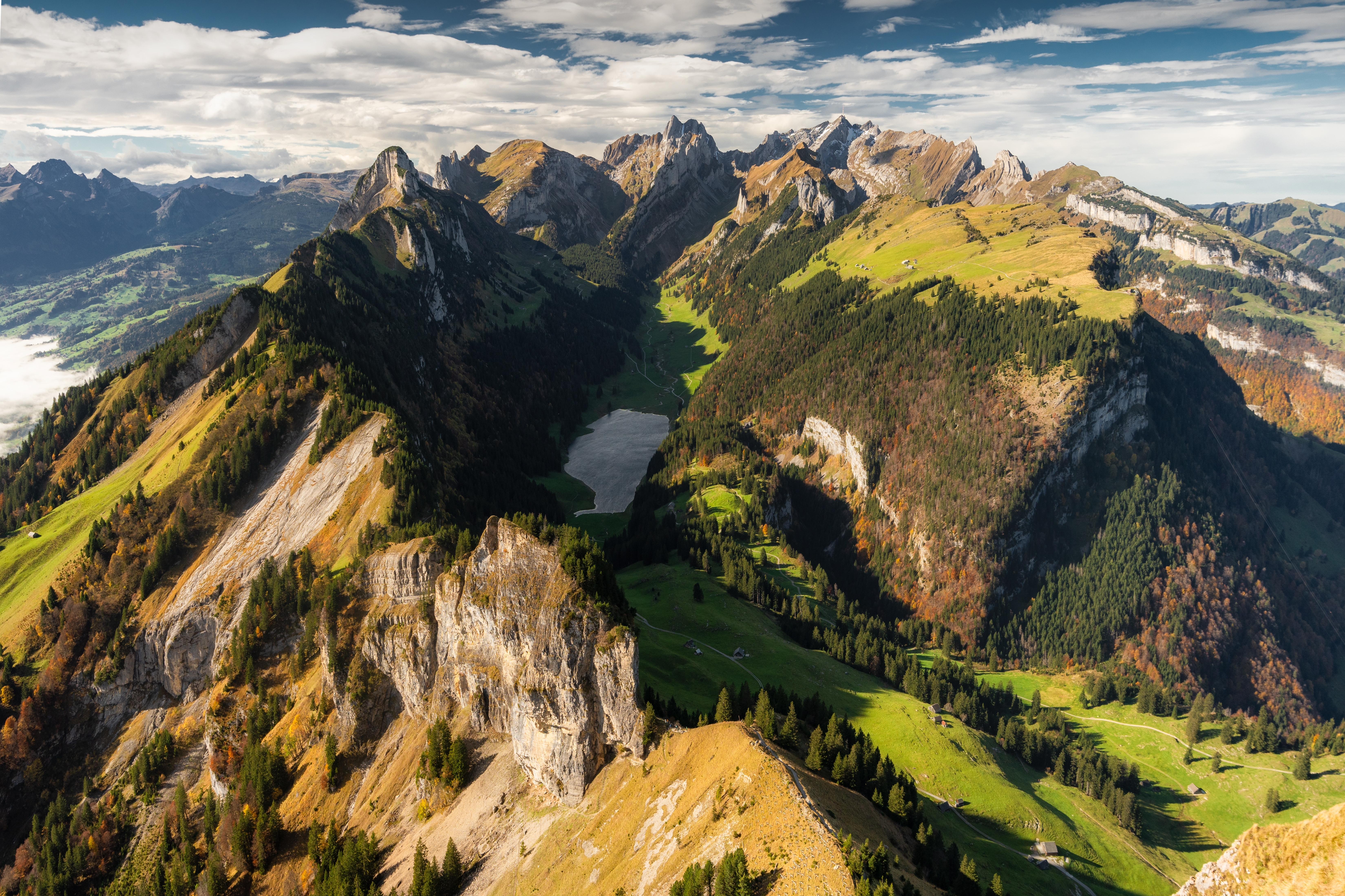 Smukke schweiziske alper nær Appenzell med en rolig bjergso omgivet af grønne bjergsider og markante klippetinder i efterårslandskab