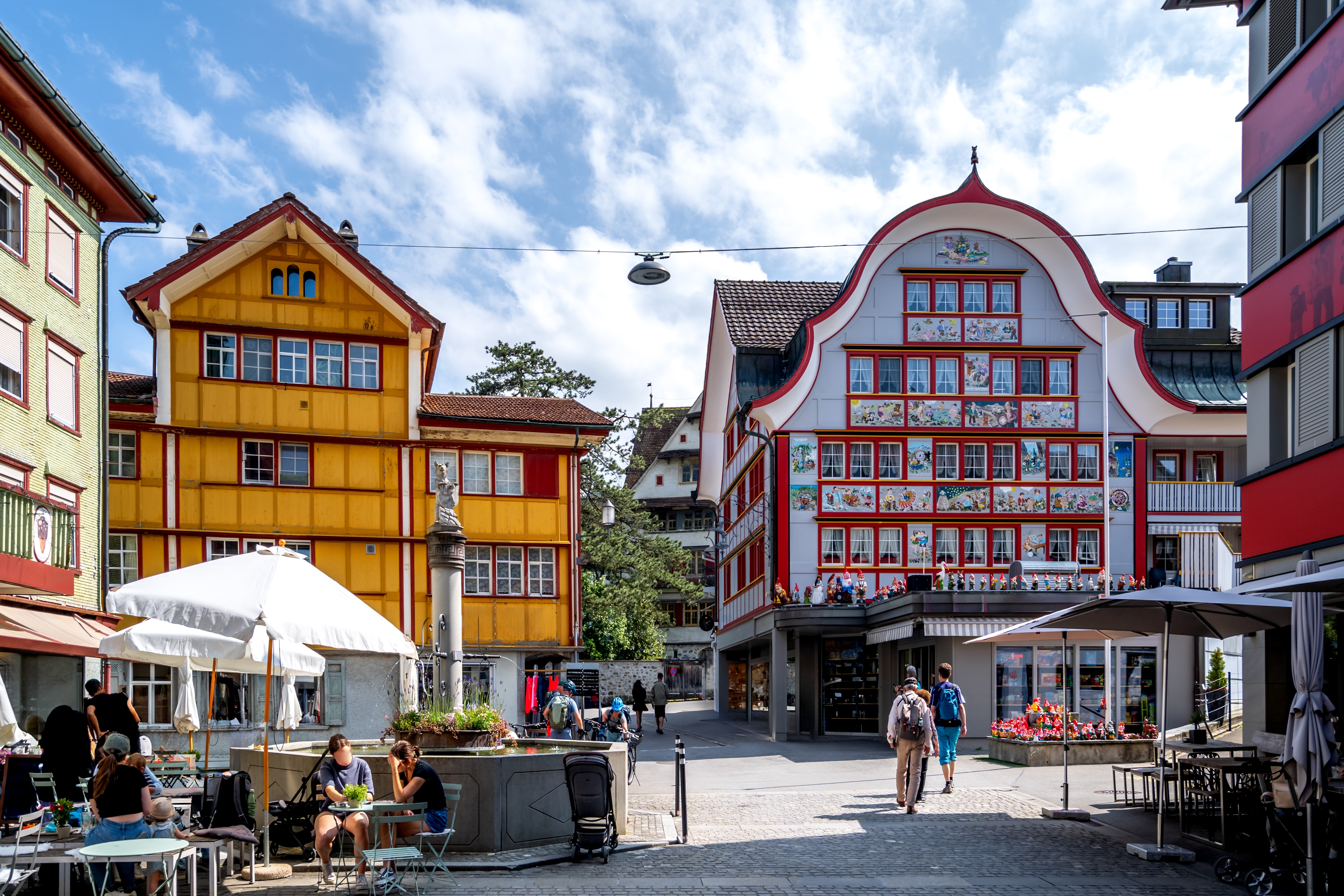 Idyllisk torv med traditionelle schweiziske gavlhuse og café i Appenzell Innerrhoden