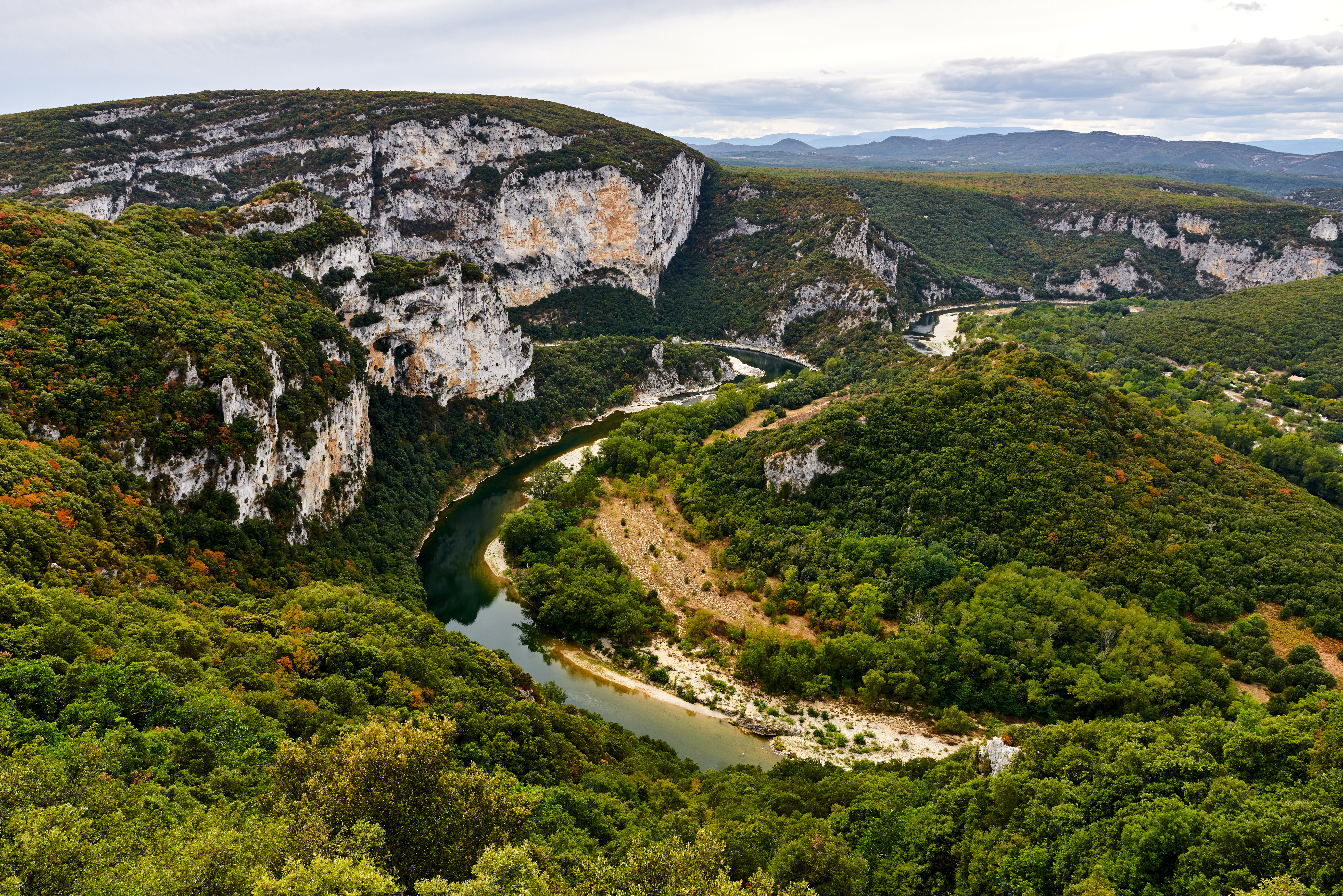 Flot udsigt over Gorges de l'Ardèche i det sydlige Frankrig, med den bugtende Ardèche-flod der slynger sig gennem de imponerende kalkstensformationer og grønne skove