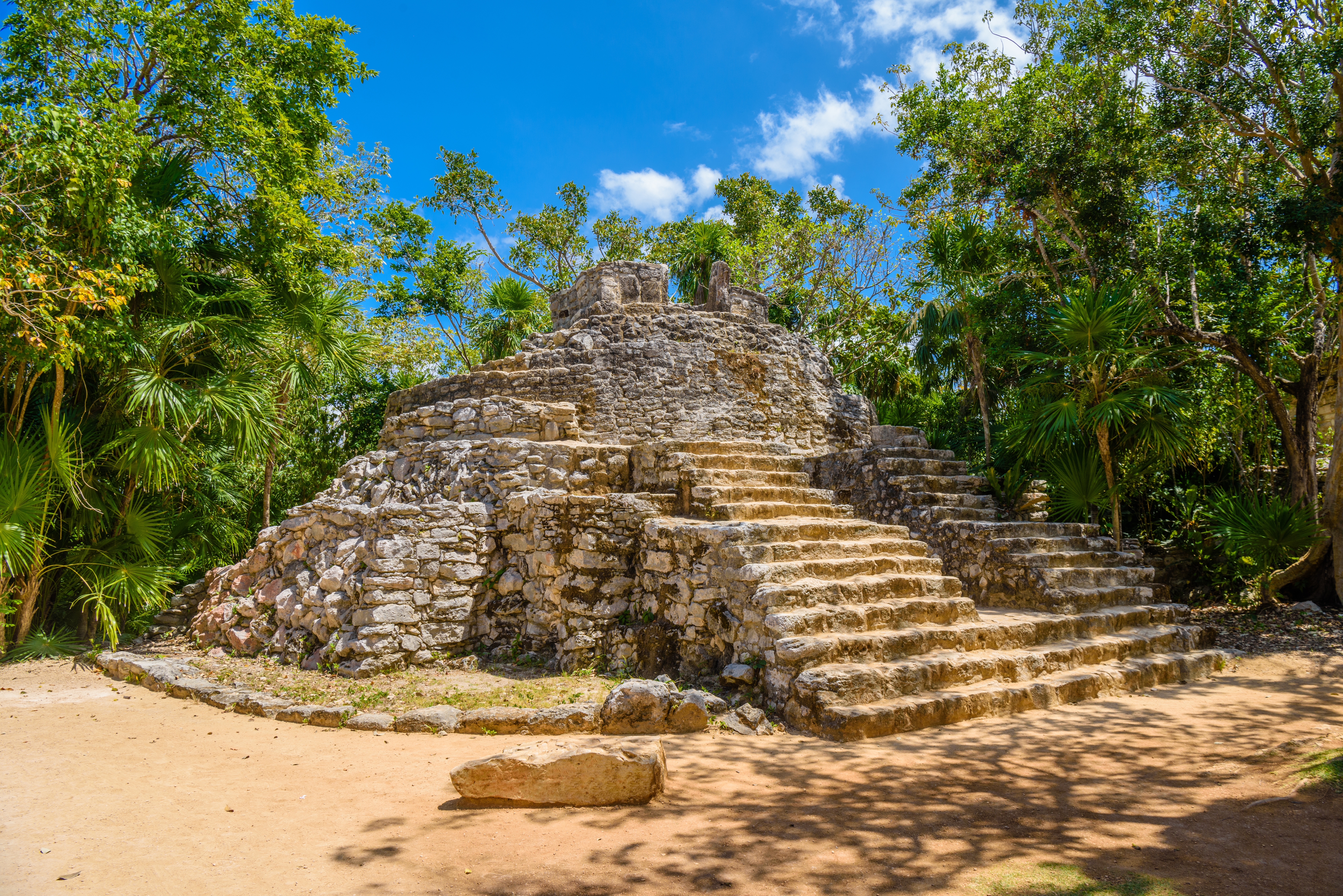 Arkæologisk mayasite med stentempler omgivet af grøn jungle i Riviera Maya, Mexico - et vidnesbyrd om den rige kulturarv