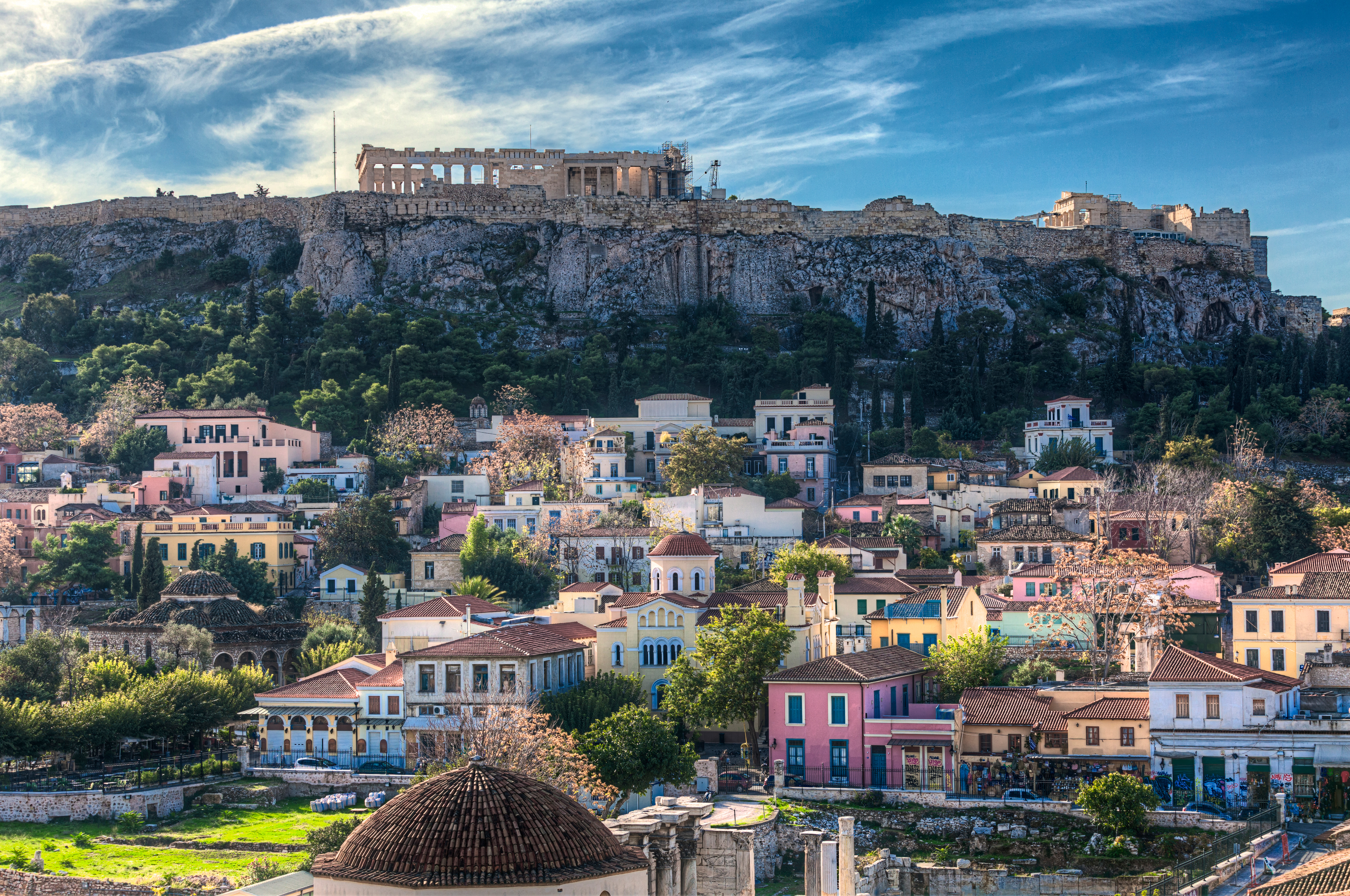 Athens ikoniske Akropolis med antikke templer og ruiner der troner over de pittoreske farverige huse i byen