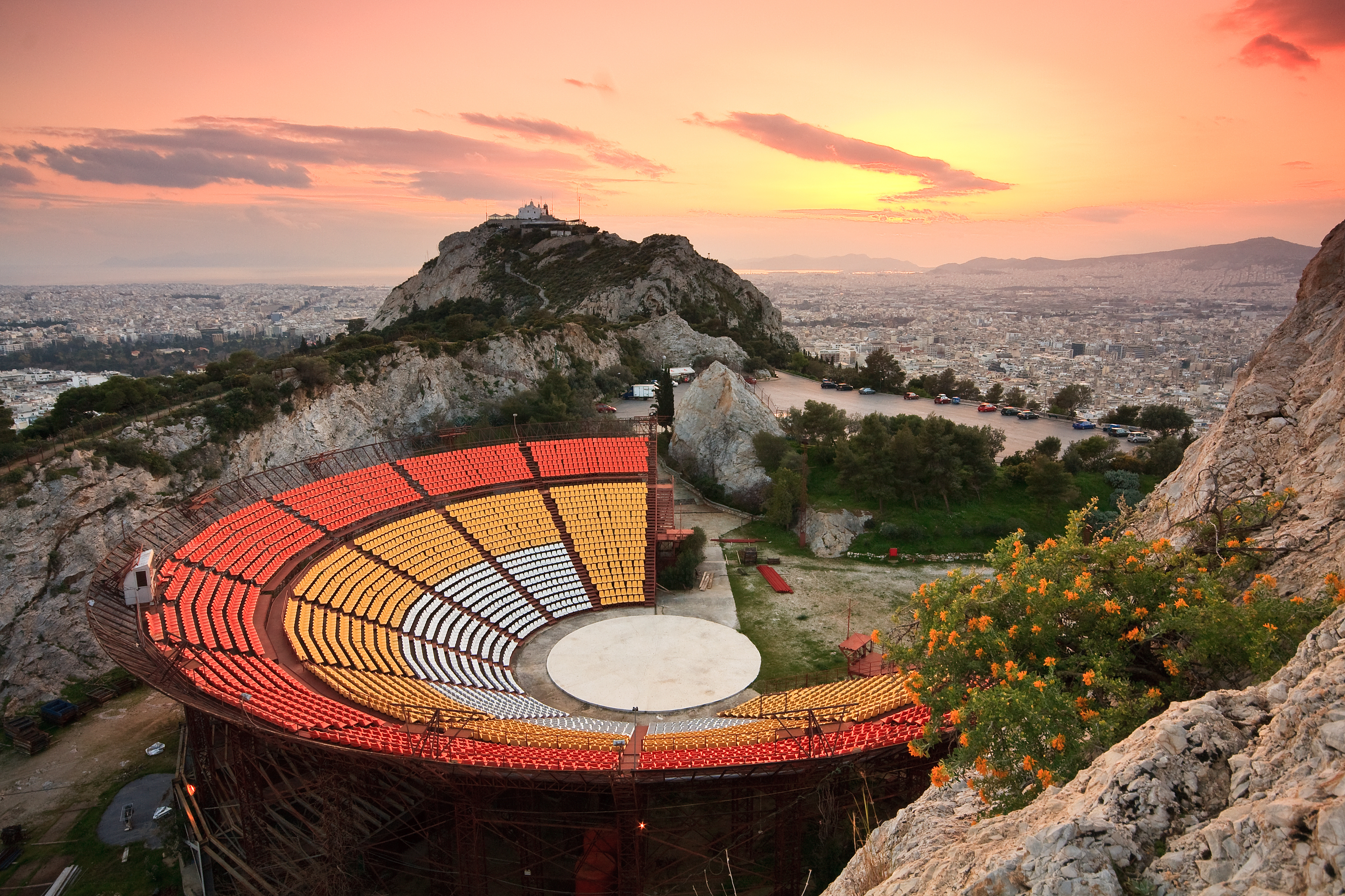 Amfiteater på Lycabettus-bakken i Athen med farverig solnedgang og panoramaudsigt over Grækenlands hovedstad