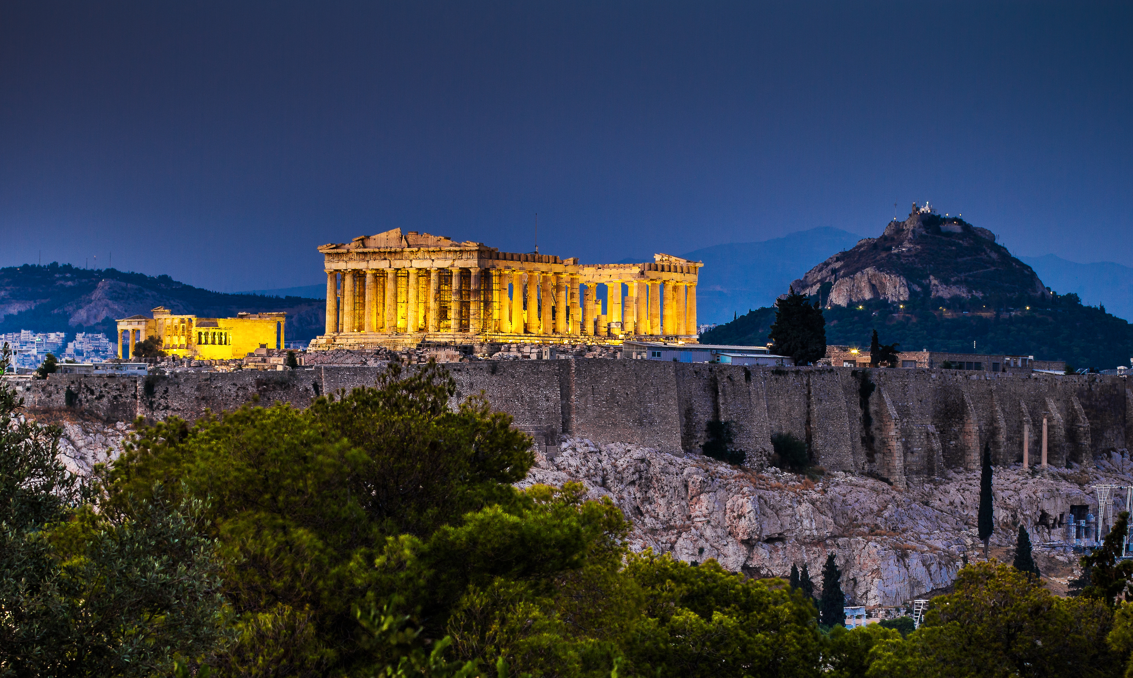 Smukt oplyst Parthenon på Akropolis i Athen fotograferet ved tusmørke mod en dyb blå nattehimmel, Grækenland