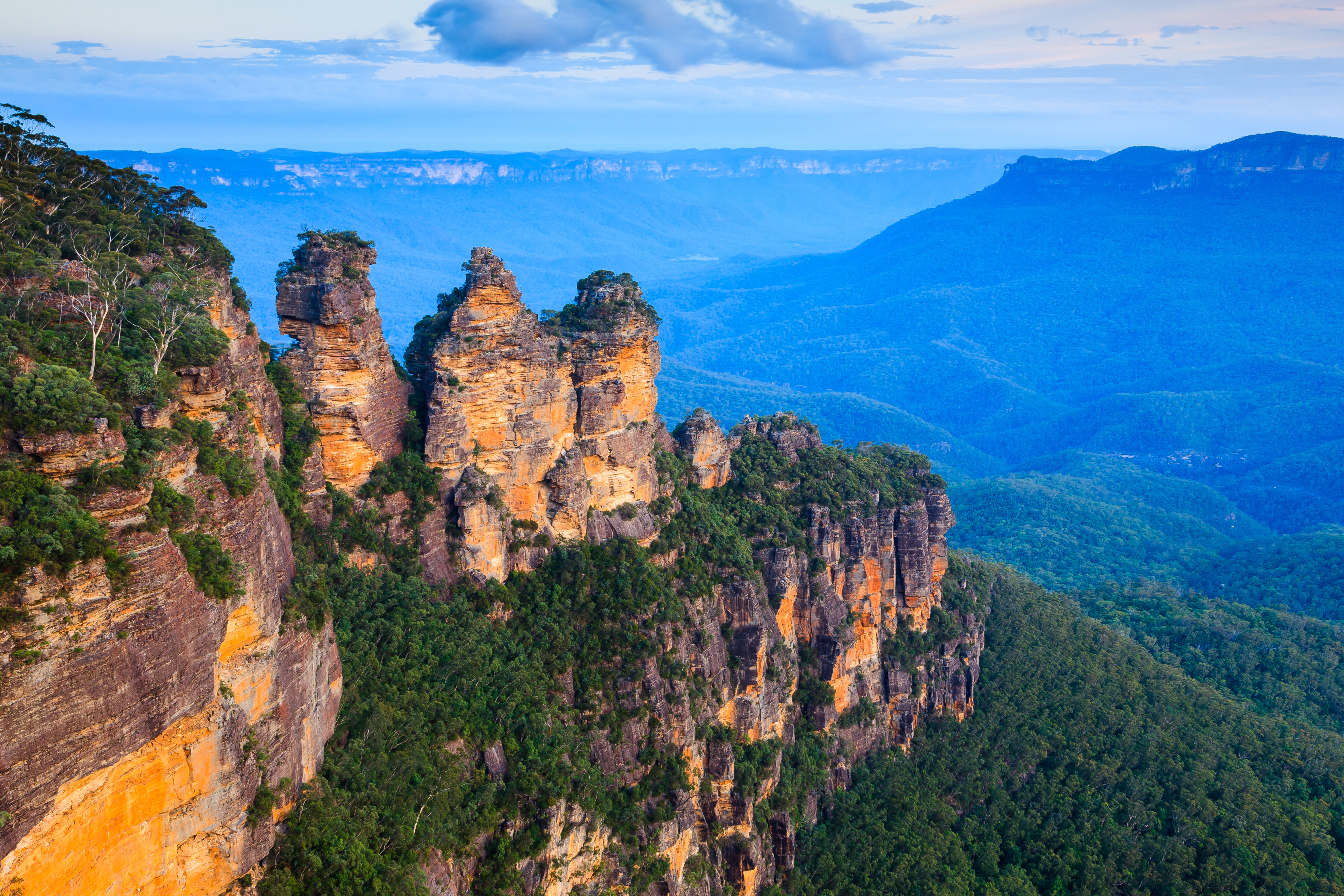 Fascinerende aftenudsigt over de ikoniske Three Sisters sandstensformationer badet i gyldent solnedgangslys, fotograferet fra det berømte Echo Point i Blue Mountains National Park, New South Wales, Australien