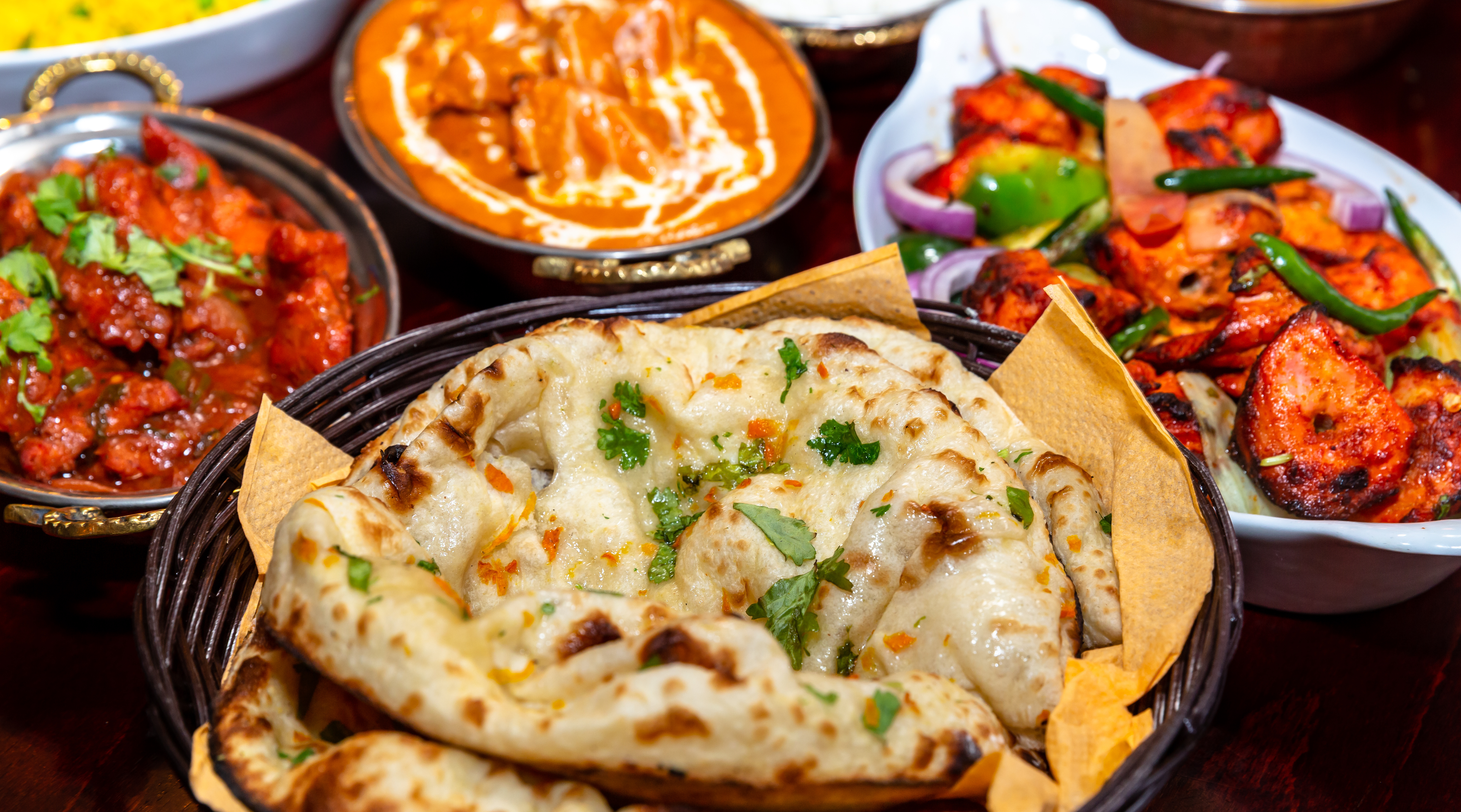 Autentisk indisk madkultur med sprødt naan-brød, rig butter chicken og krydret tandoori serveret i traditionelle fade