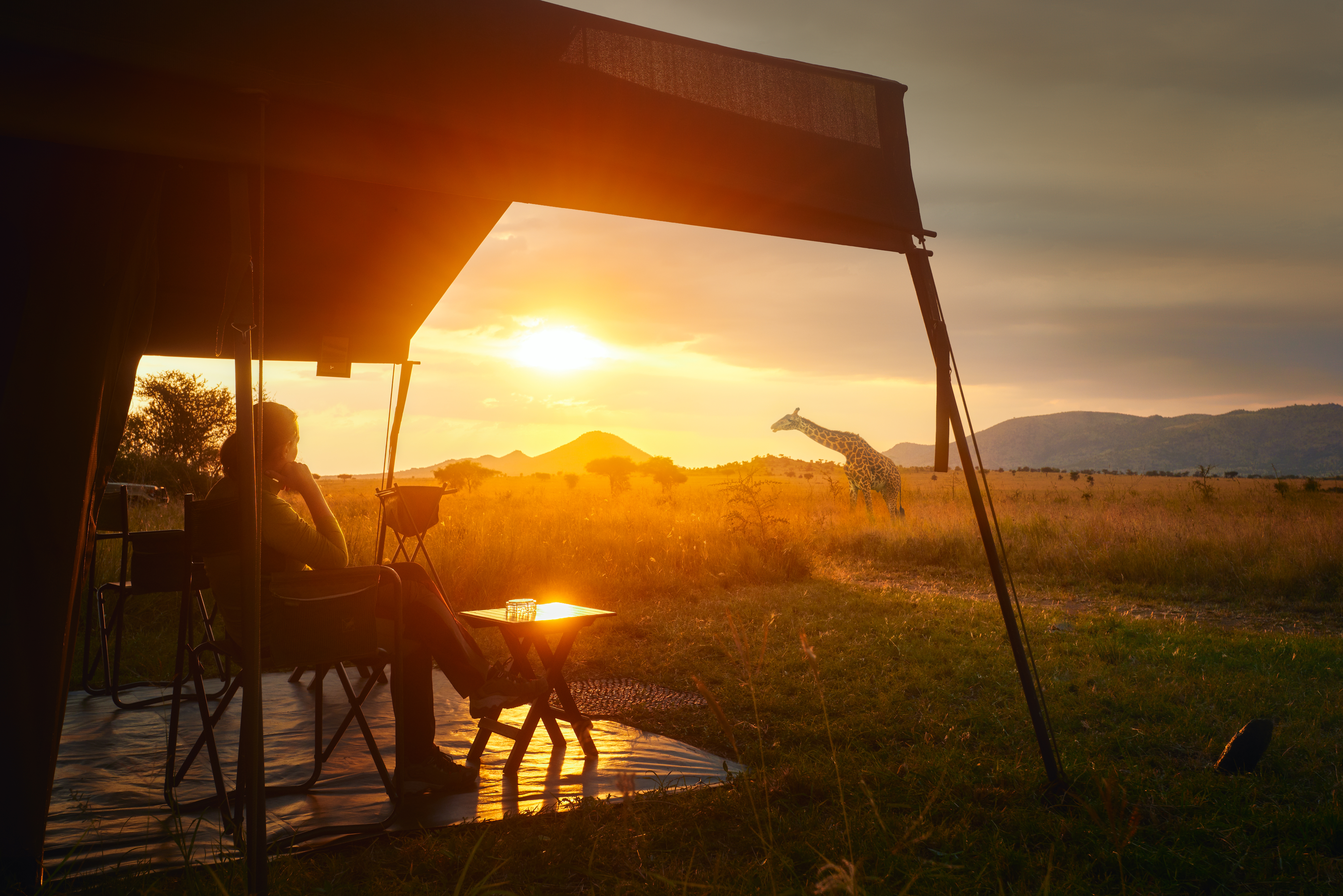 Magisk solnedgang over savannen oplevet fra luksuriøst safaritelt i Serengeti Nationalpark, Tanzania - ægte afrikansk naturoplevelse