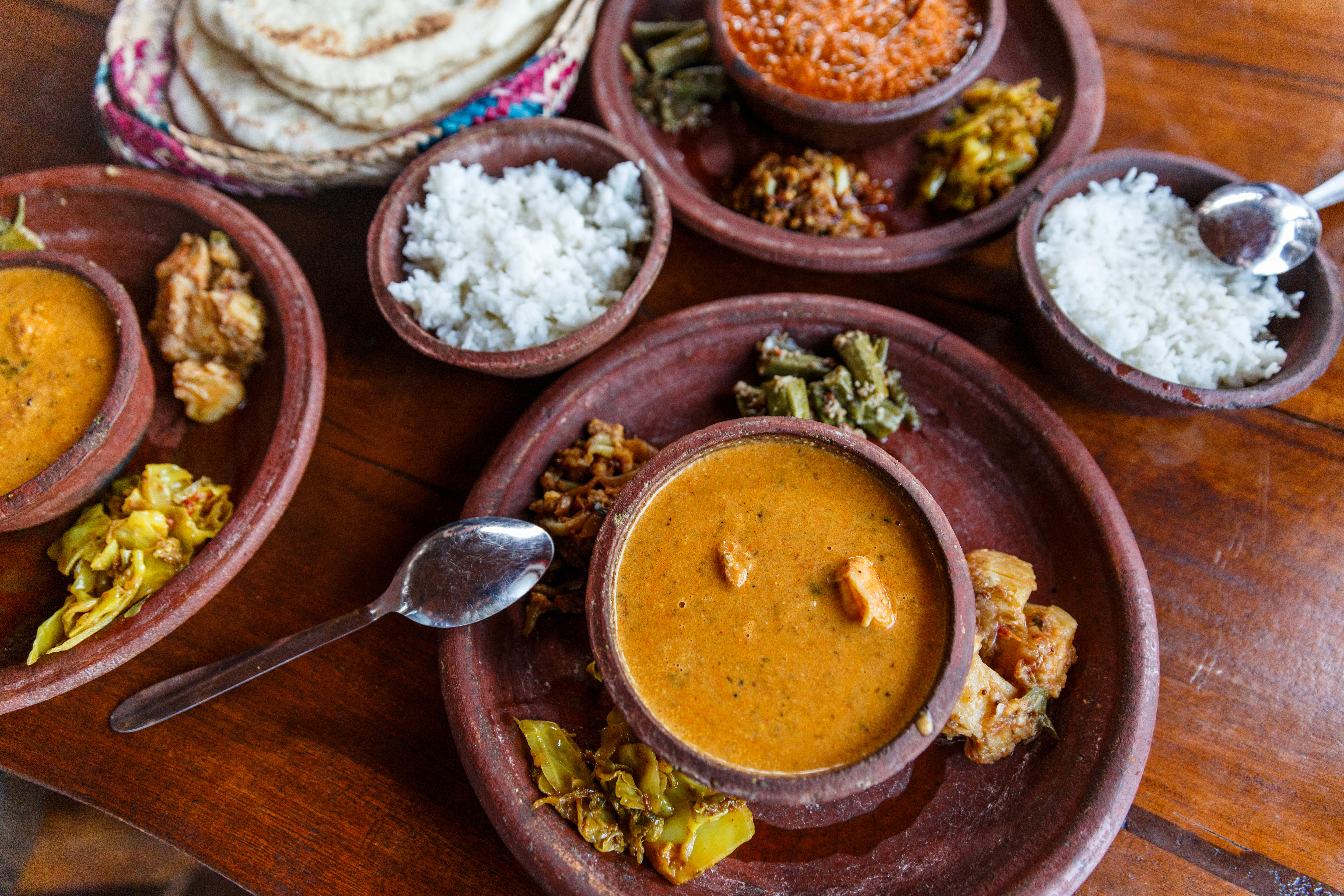 Traditionelt Sri Lankansk thali måltid med aromatisk karry, ris, grøntsager og fladbrød i rustikke lerskåle