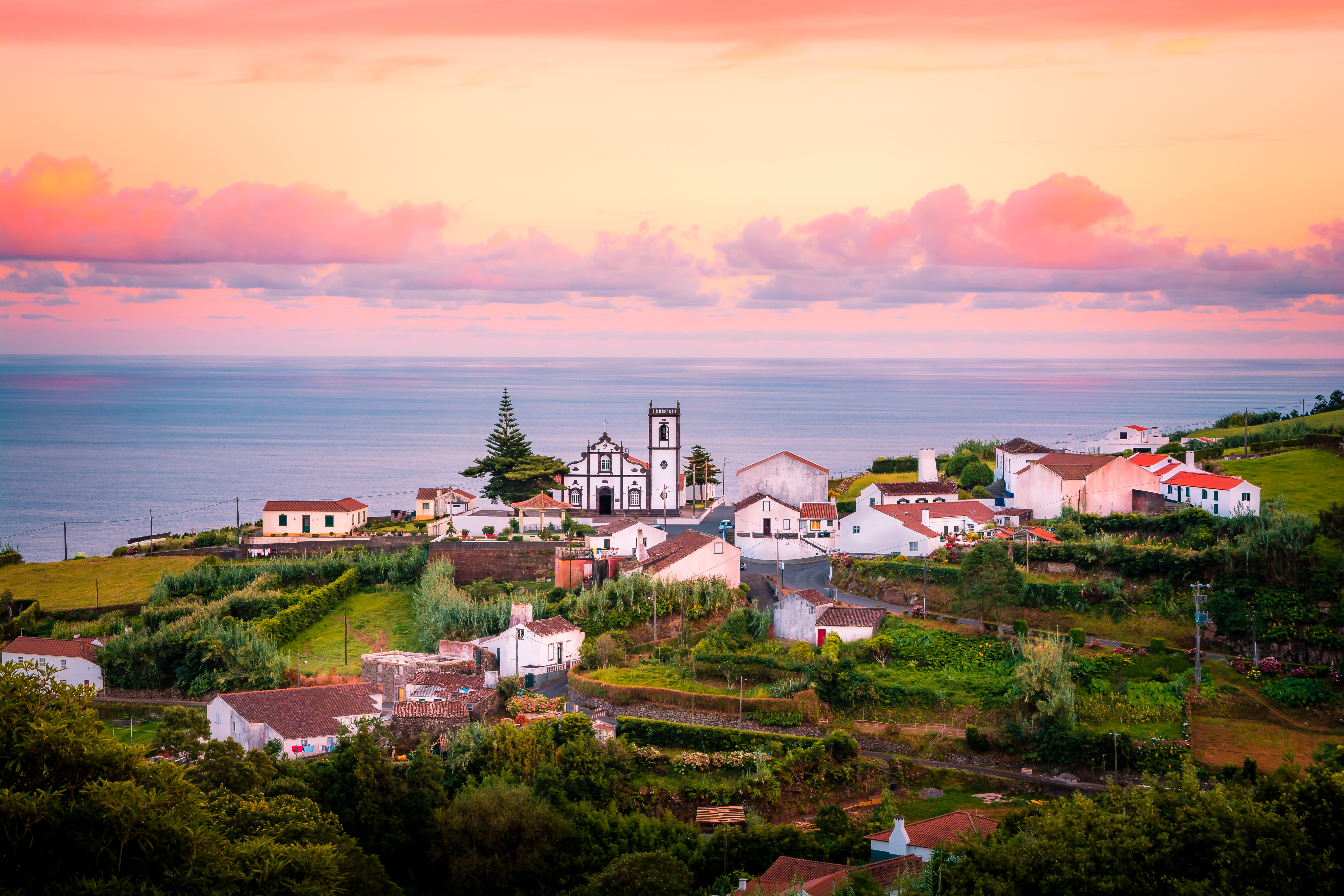 Drømmende rosa solnedgang over Nordeste landsby på Azorerne med traditionel arkitektur og havudsigt