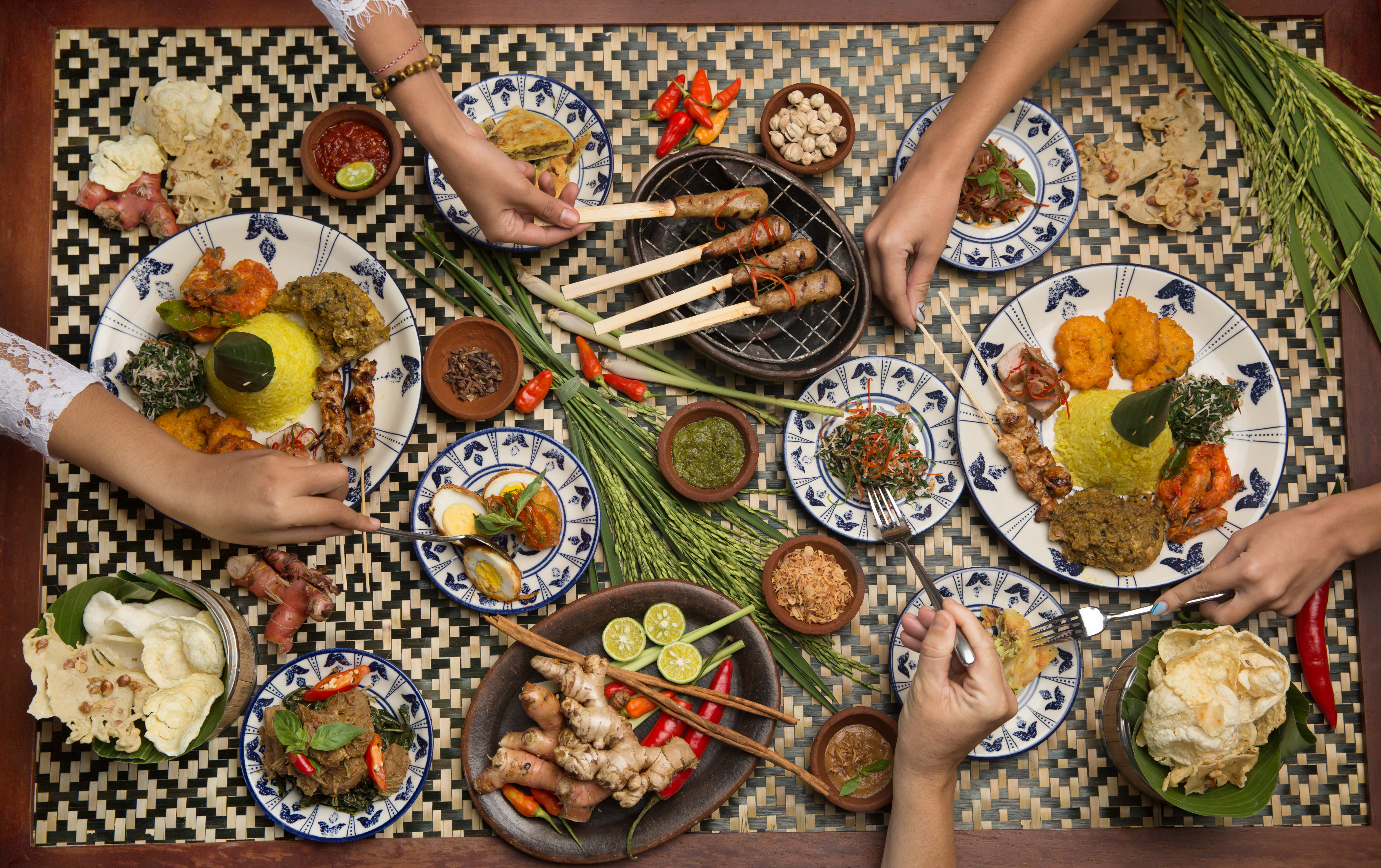 Balinesisk madkultur med traditionelle satay-spyd, ris og lokale retter serveret på naturlige banandblade