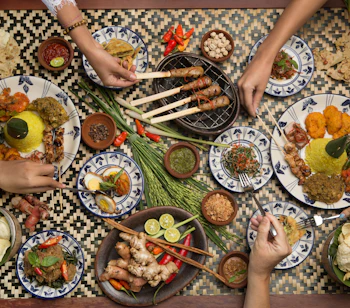 Balinesisk madkultur med traditionelle satay-spyd, ris og lokale retter serveret på naturlige banandblade
