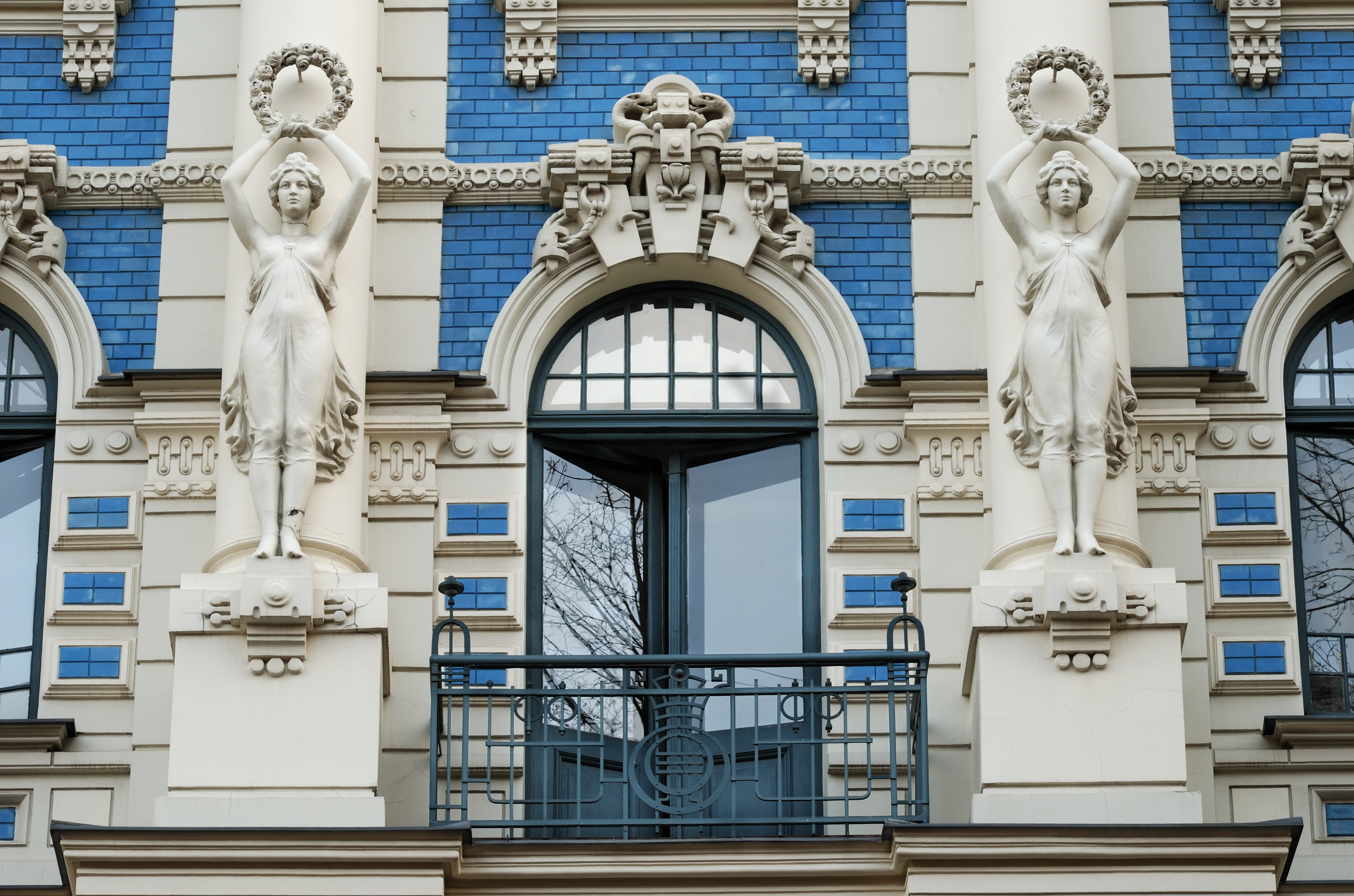 Ornamenteret bygningsfacade med kvindelige statuer og art nouveau elementer i Rigas centrum