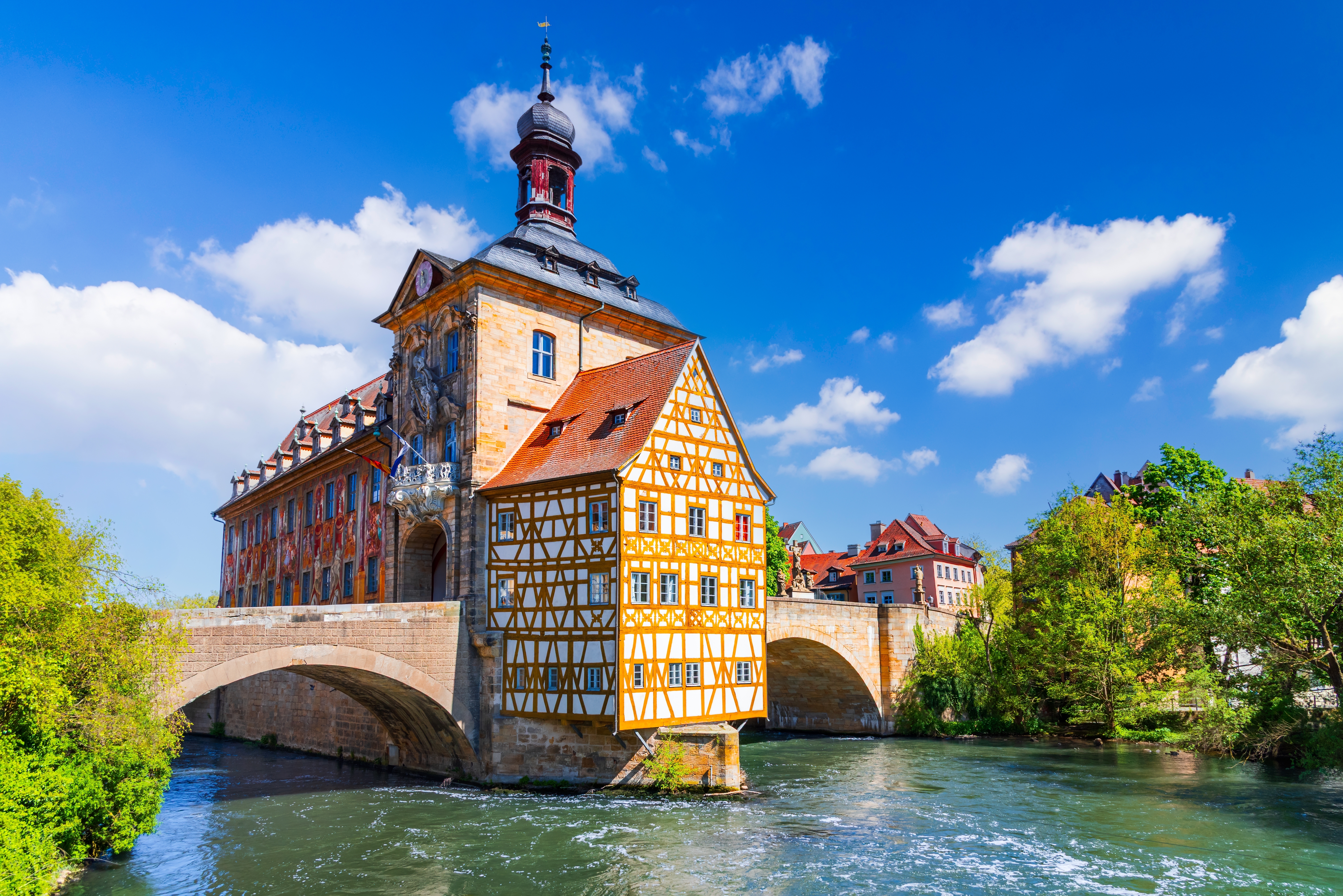 Bambergs smukke gamle rådhus fra middelalderen bygget direkte på en bro over Regnitz-floden i Bayern, Tyskland, med gul og hvid bindingsværksfacade