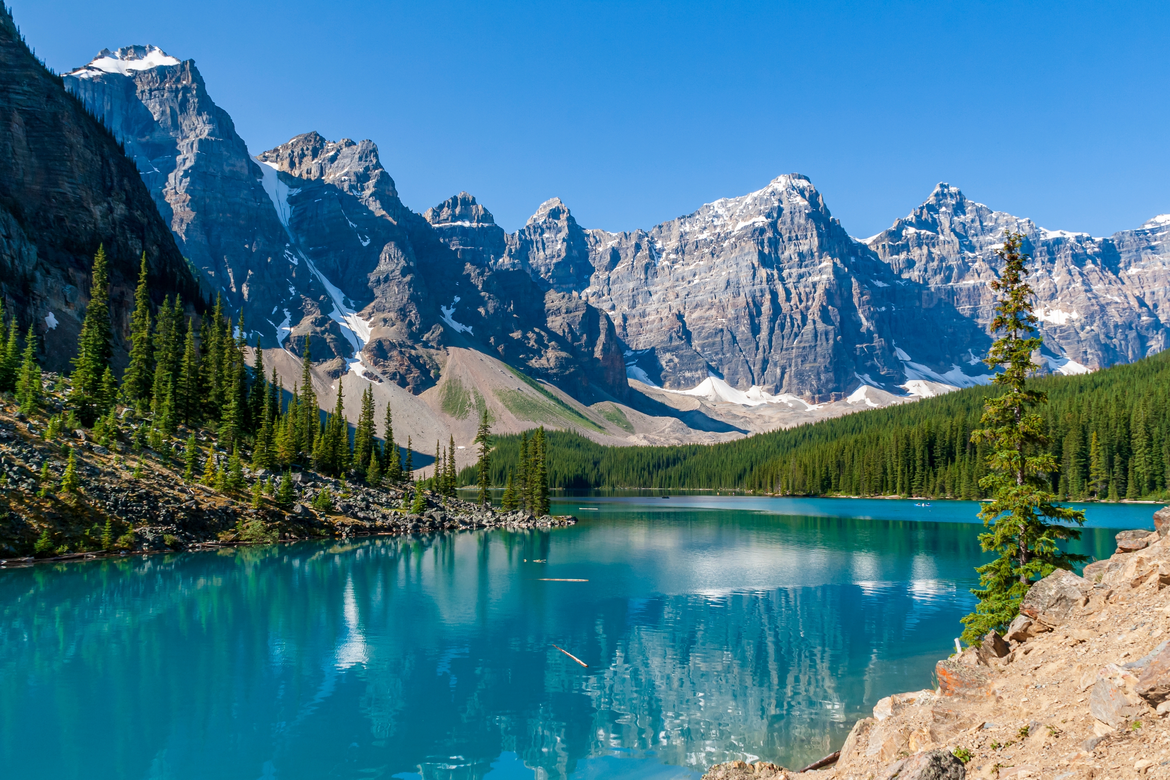 Naturskøn bjergsø med perfekte refleksioner af snedækkede toppe i Banff Nationalpark