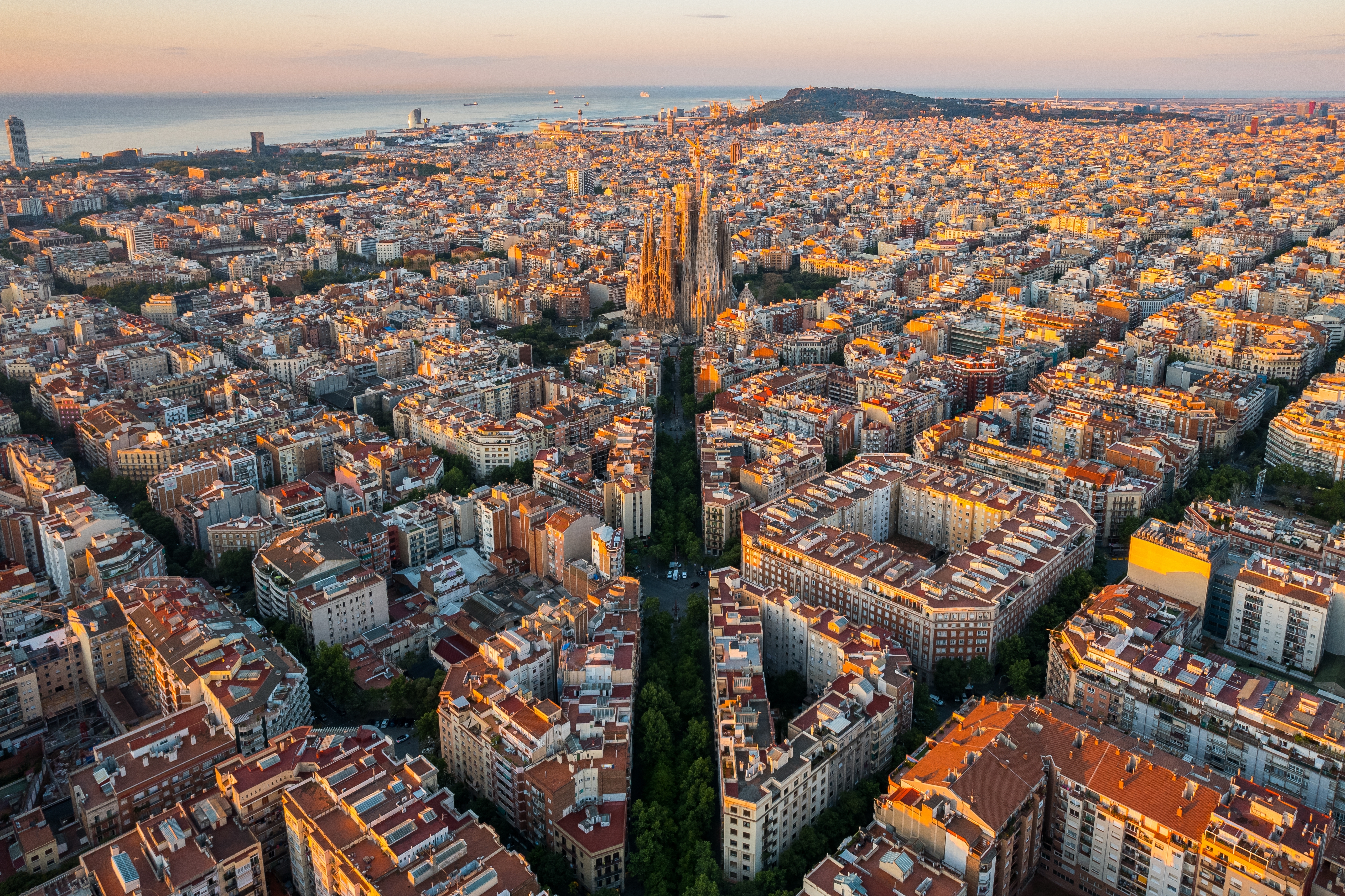 Storslået morgenudsigt over Barcelona fra oven med den verdensberømte Sagrada Familia basilika og byens karakteristiske Eixample-kvarter
